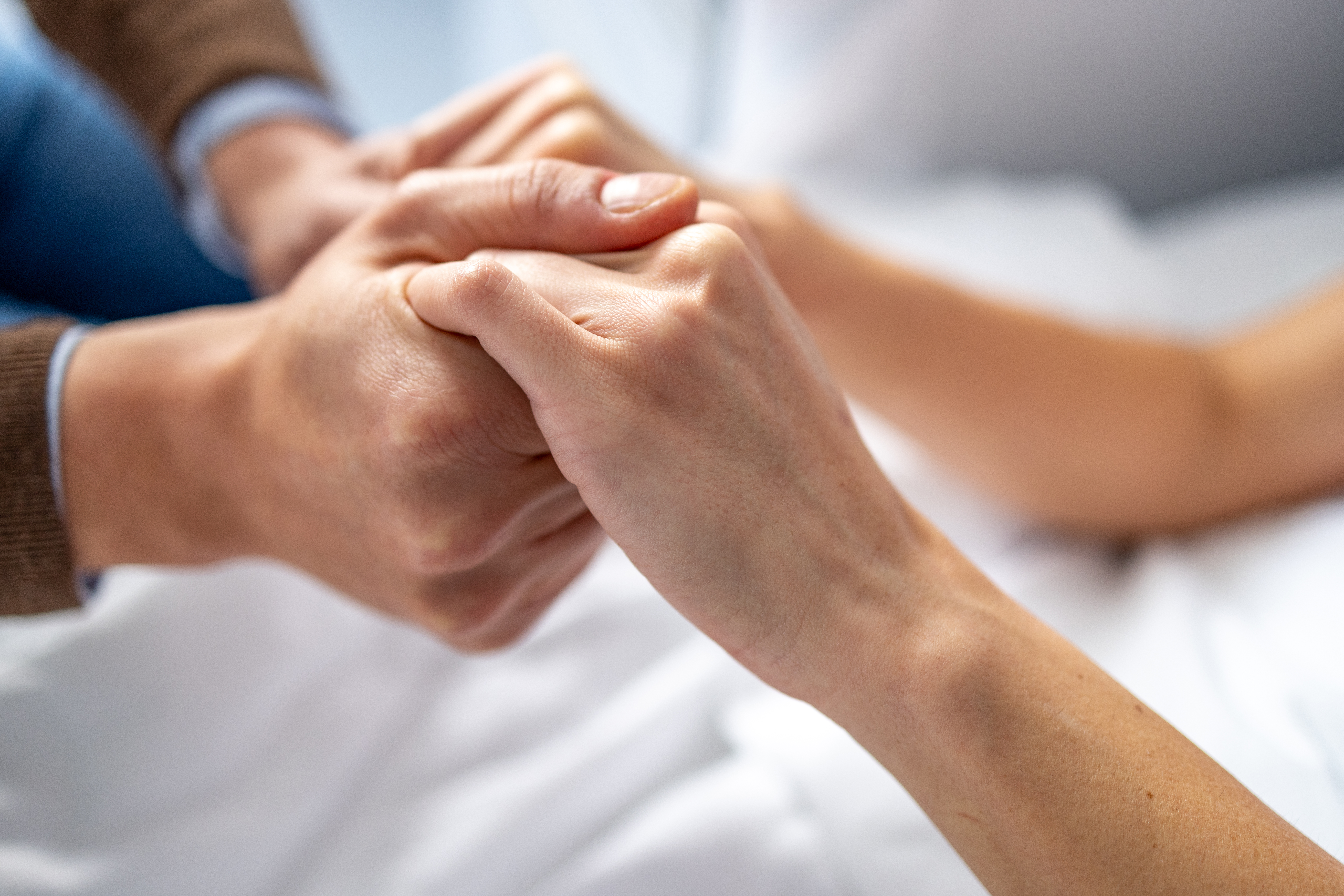 Man holding woman hand in hospital bed. | Source: Getty Images