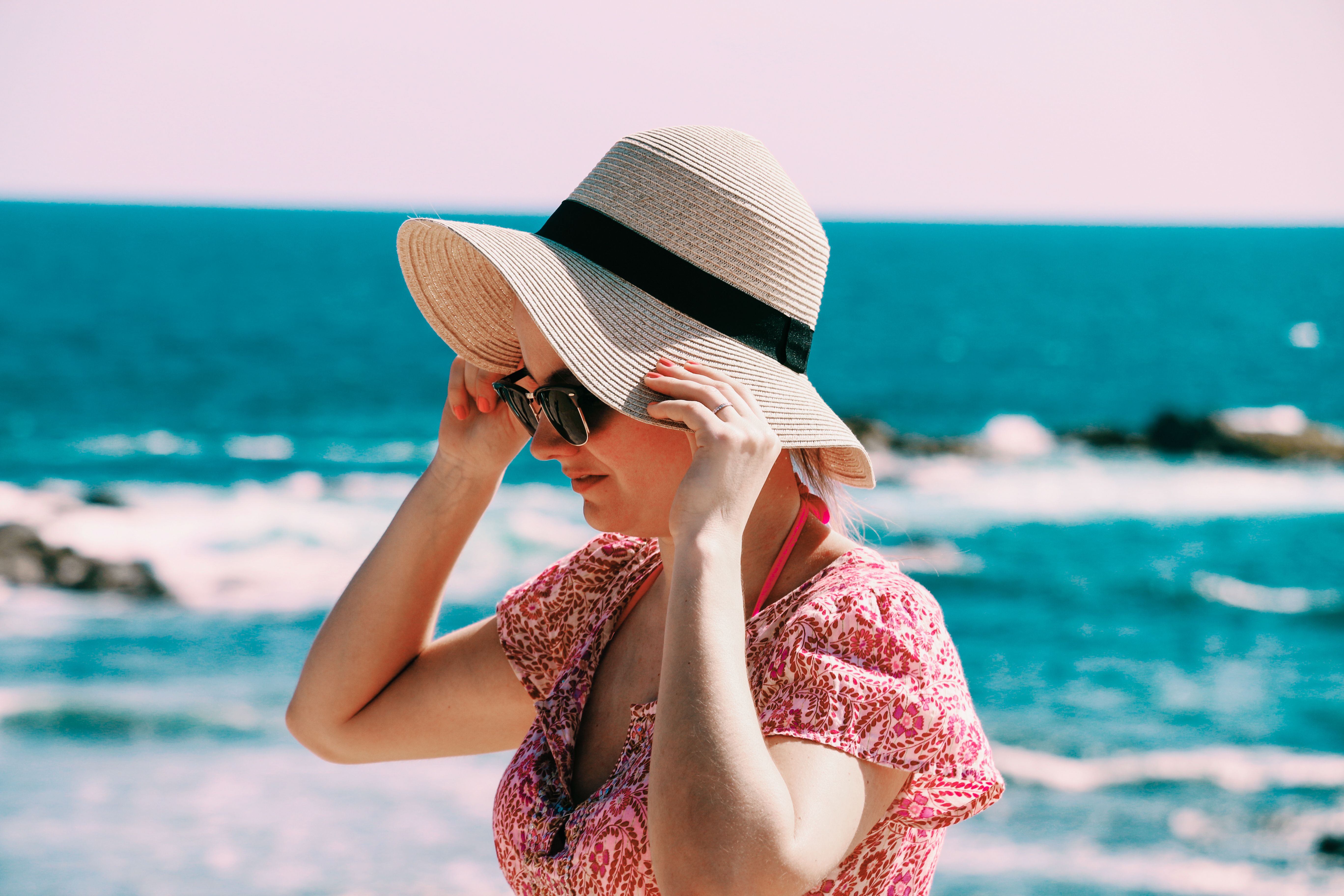 Woman wearing a hat and sunglasses at the beach | Source: Pexels