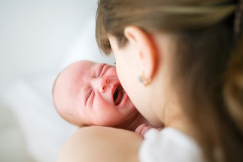Mutter hält weinendes Baby im Arm | Quelle: Shutterstock