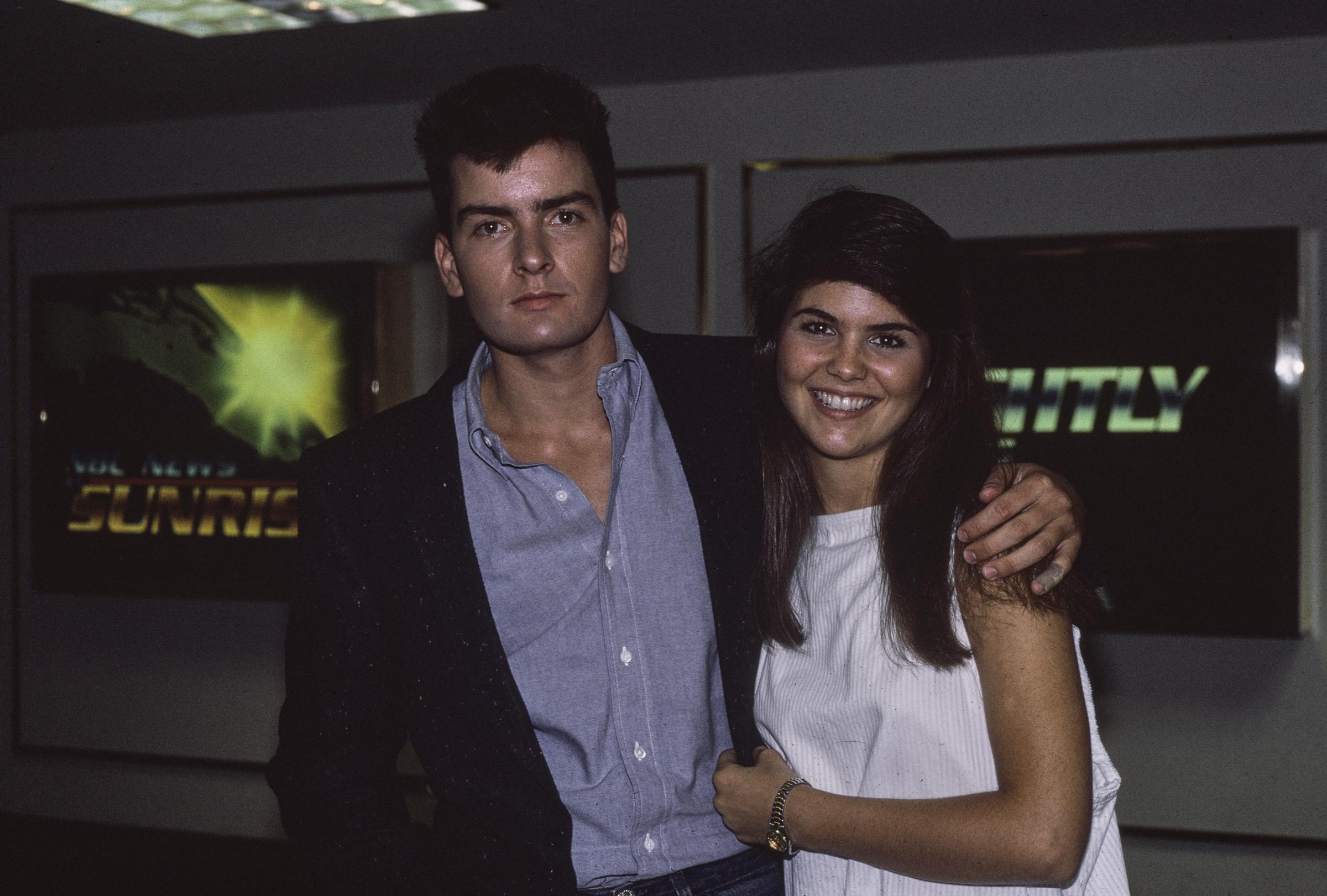 Lori Loughlin was pictured with fellow actor Charlie Sheen, circa 1987. The young actress wore a sleeveless white bateau-neck dress, smiling brightly.