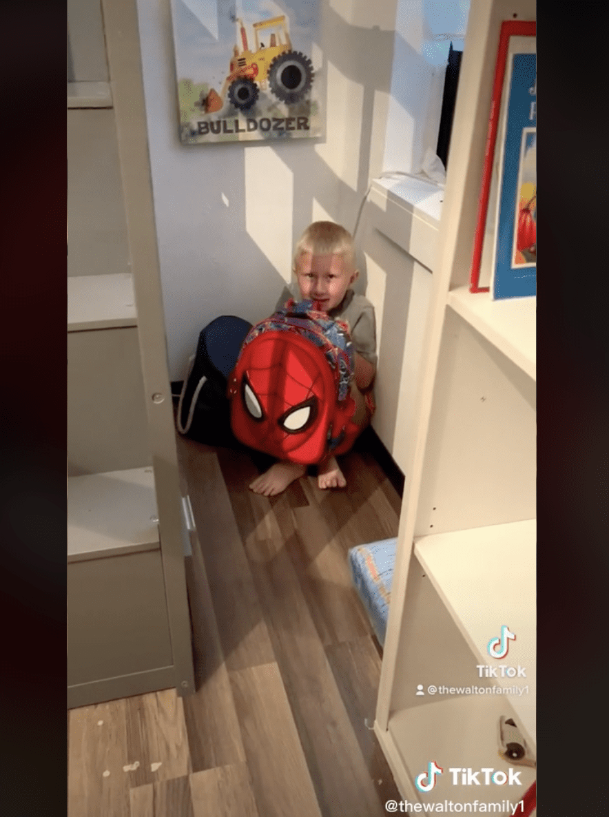 Weston hides in a corner with his bulletproof backpack. | Source: Tiktok.com/@thewaltonfamily1