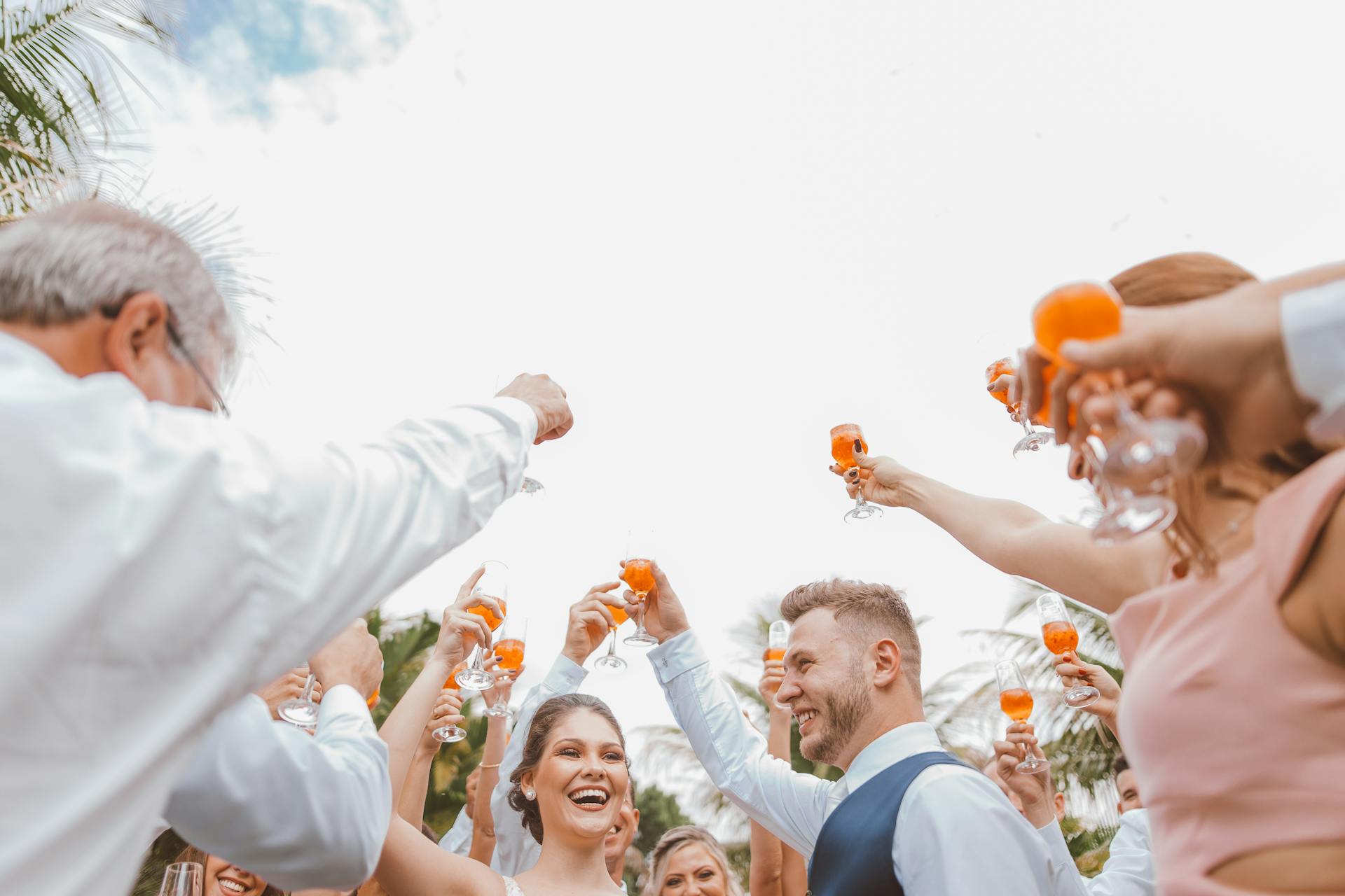 People raising their drinks to toast during a wedding reception | Source: Pexels