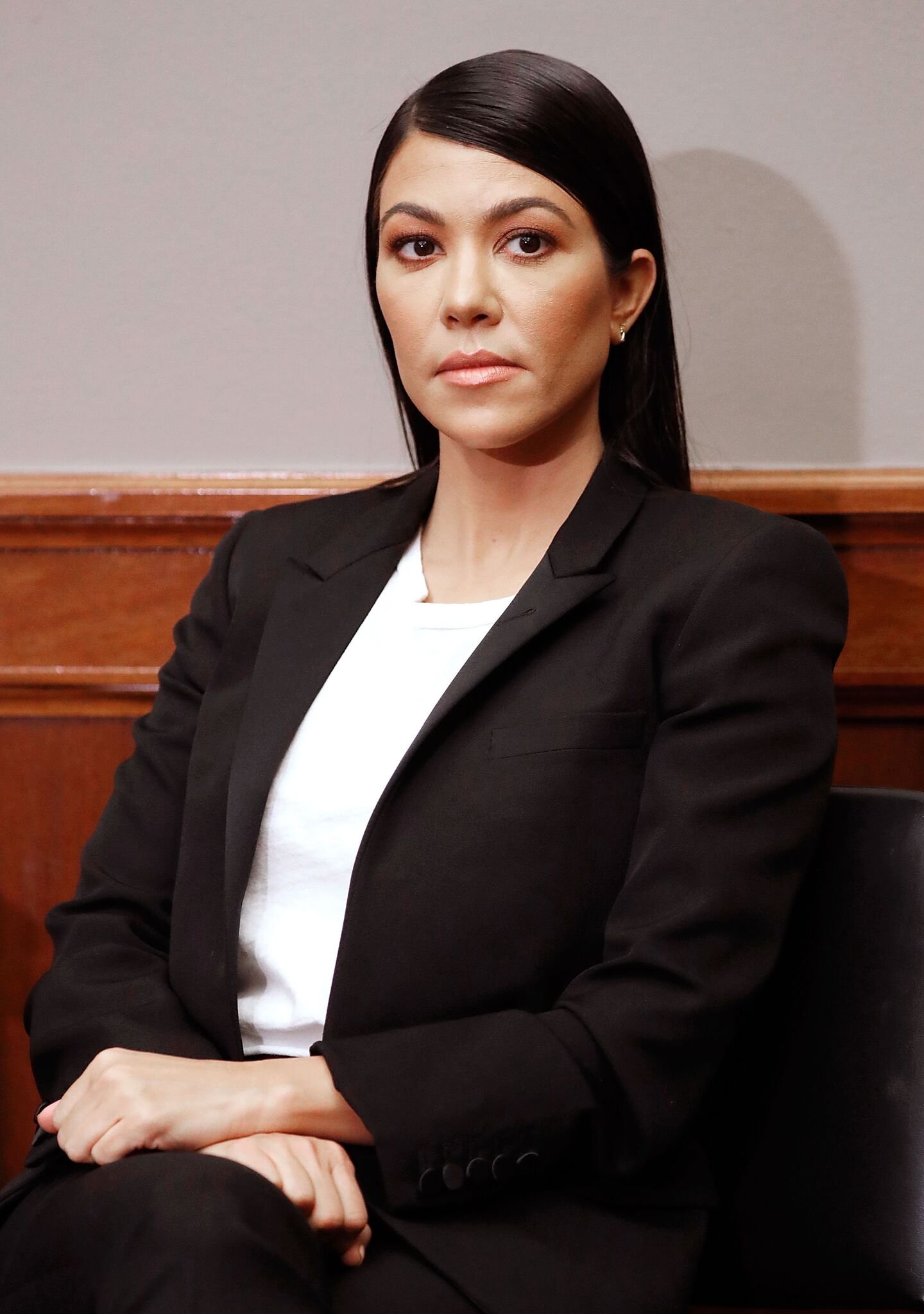 Kourtney Kardashian poses while sitting down | Getty Images