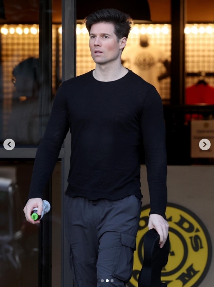 Model Kevin Baker was seen exiting the gym in coordinated athleisure alongside long-time partner Calvin Klein, captured in a post dated January 28, 2026. Dressed in a fitted black top and cargo trousers, Baker cut a sharp figure during the casual outing, marking yet another rare appearance with the designer. | Source: Instagram/justjared