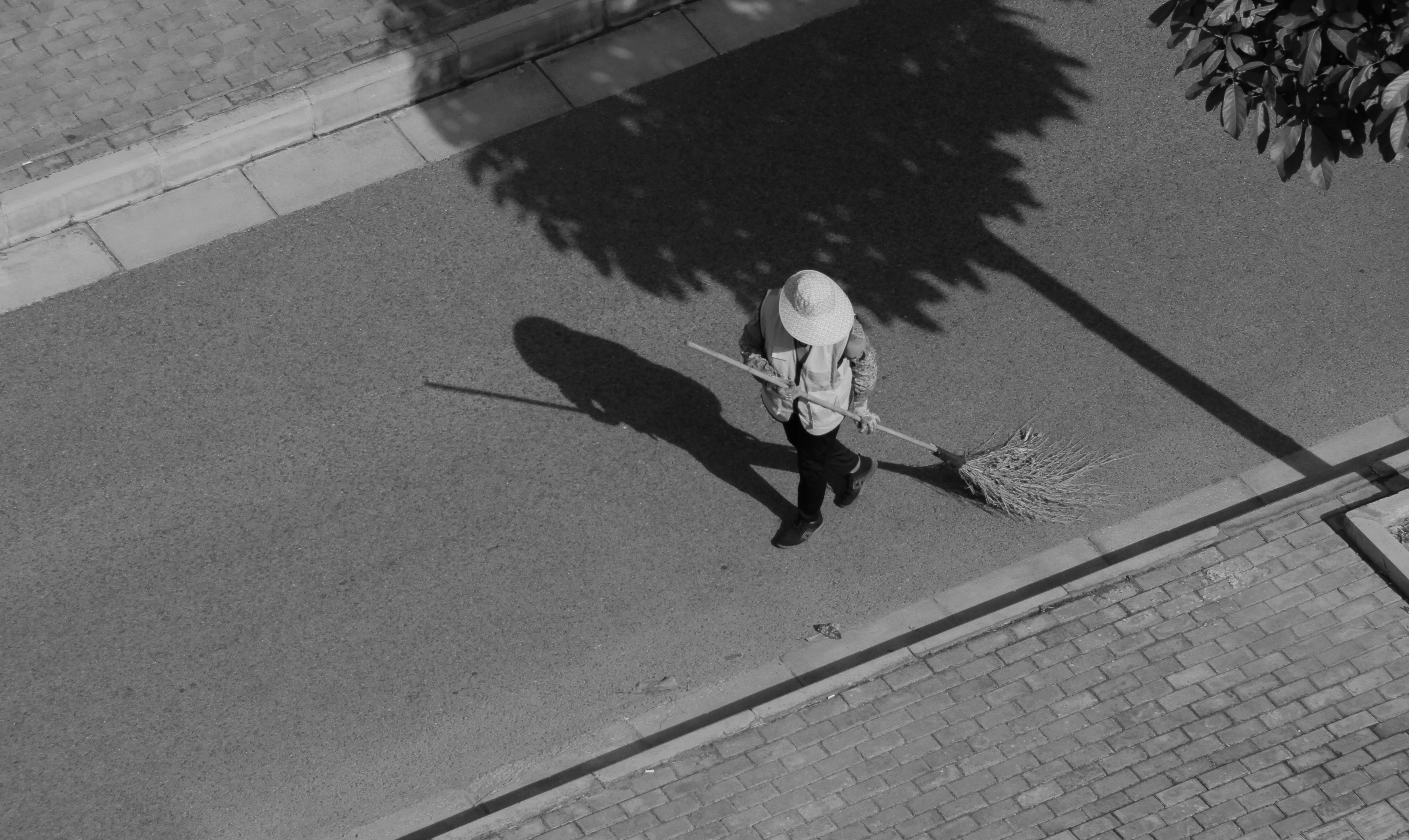 Vista desde arriba de una persona barriendo la calle. | Foto: Pexels