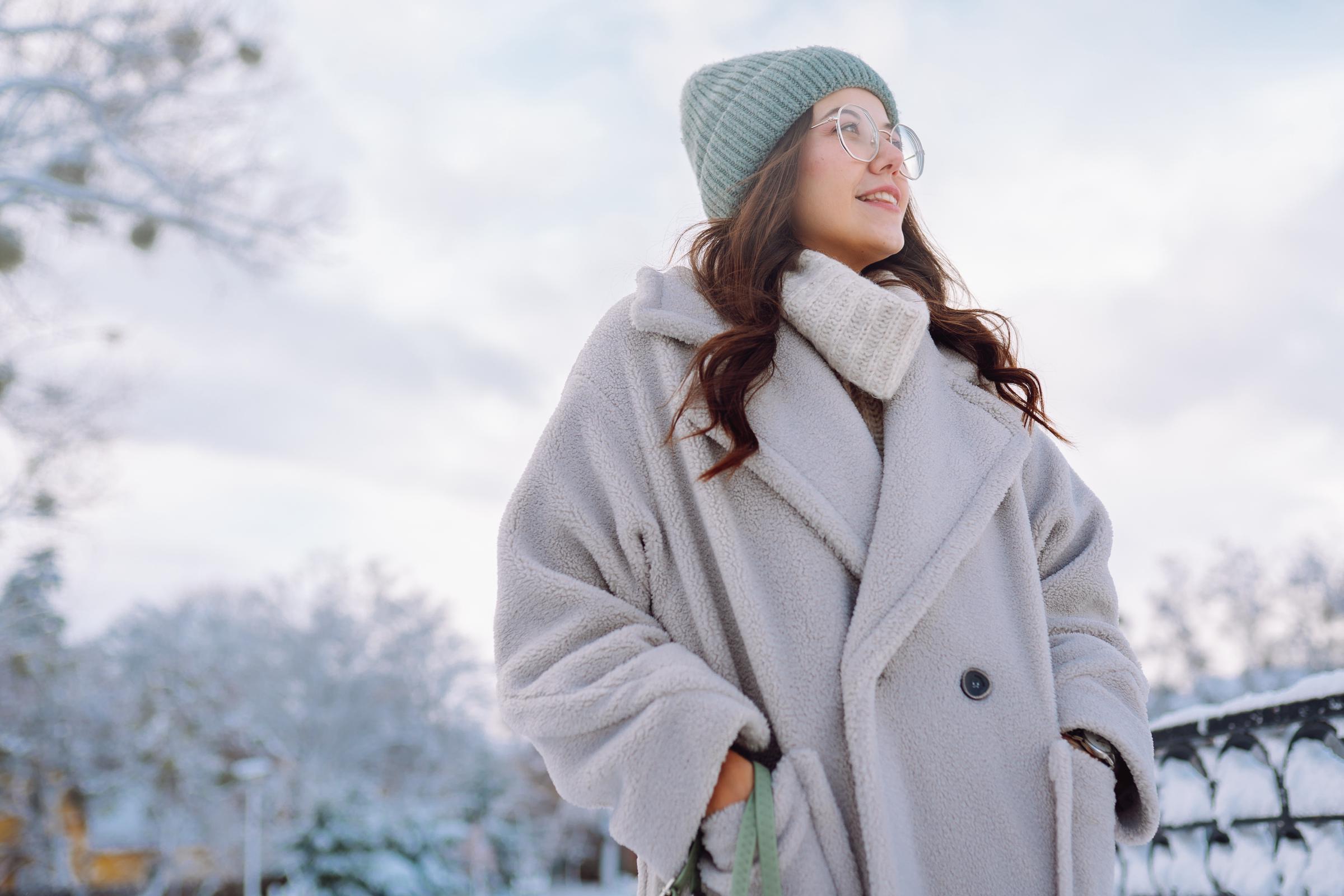 A woman wearing a winter coat out in the snow | Source: Getty Images