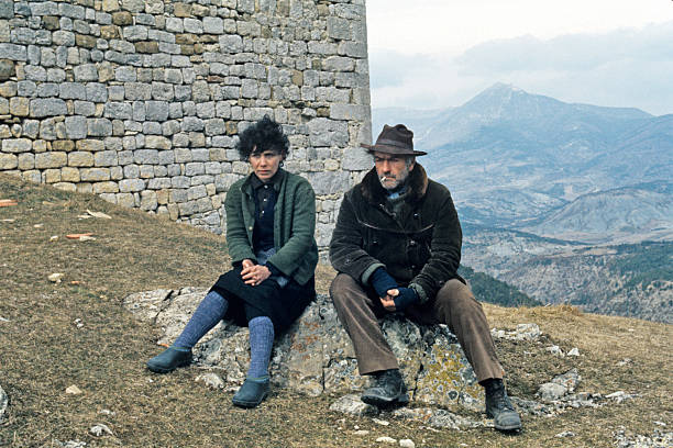 Liliane Rovère et Christian Barbier assis sur une pierre | Sources : Getty Images Liliane Rovère et Christian Barbier assis sur une pierre | Sources : Getty Images