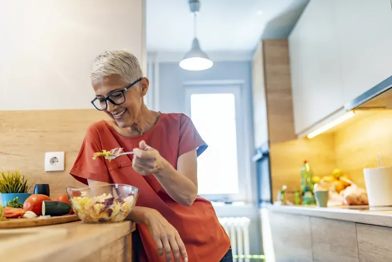 Une séniore heureuse de manger | Photo : Getty images