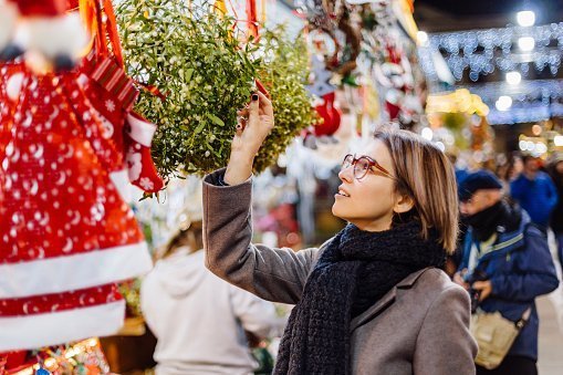 A young woman buying mistletoe at the Christmas Market | Photo: Getty Images