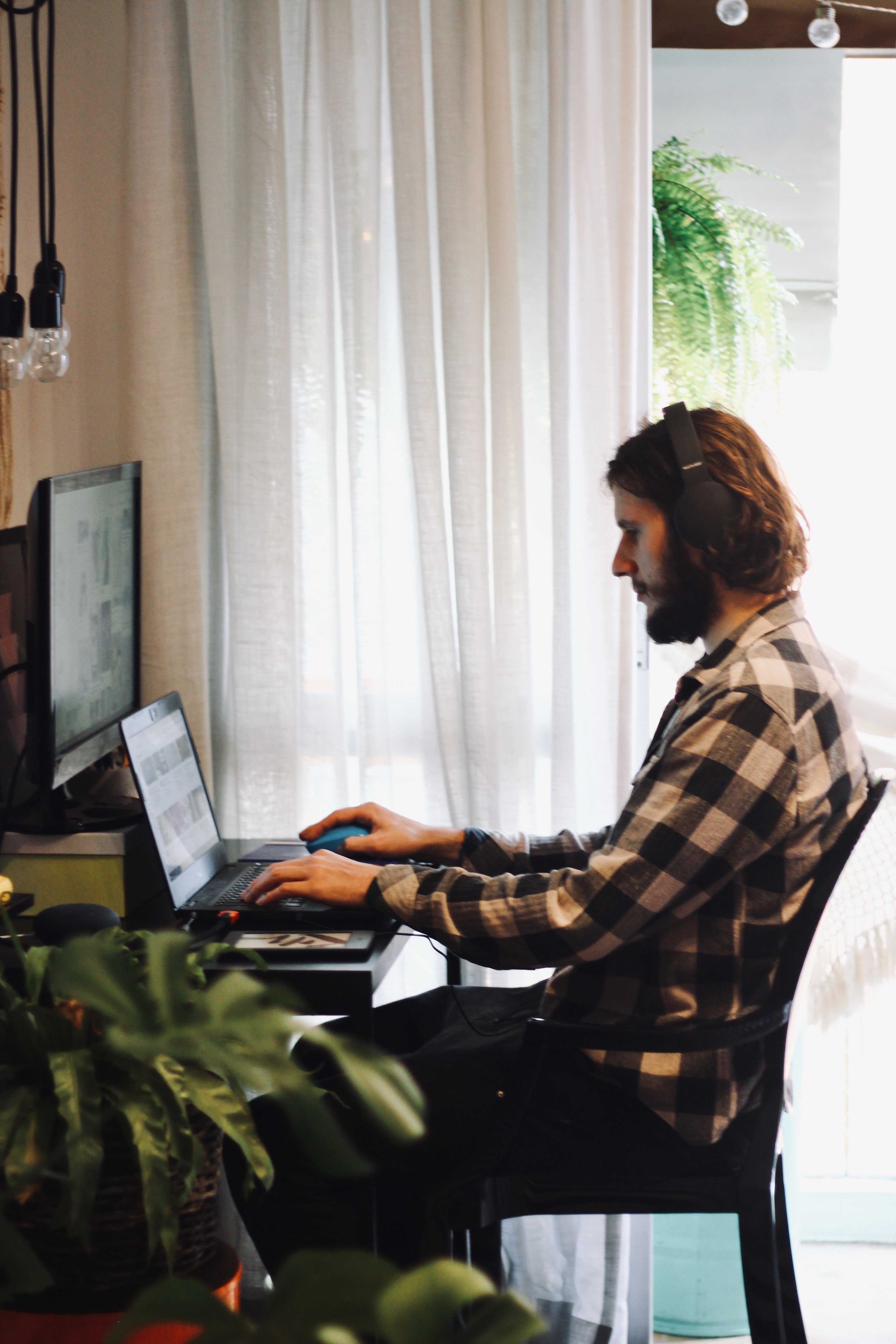 Un hombre joven trabajando frente a una computadora portátil. | Foto: Unsplash