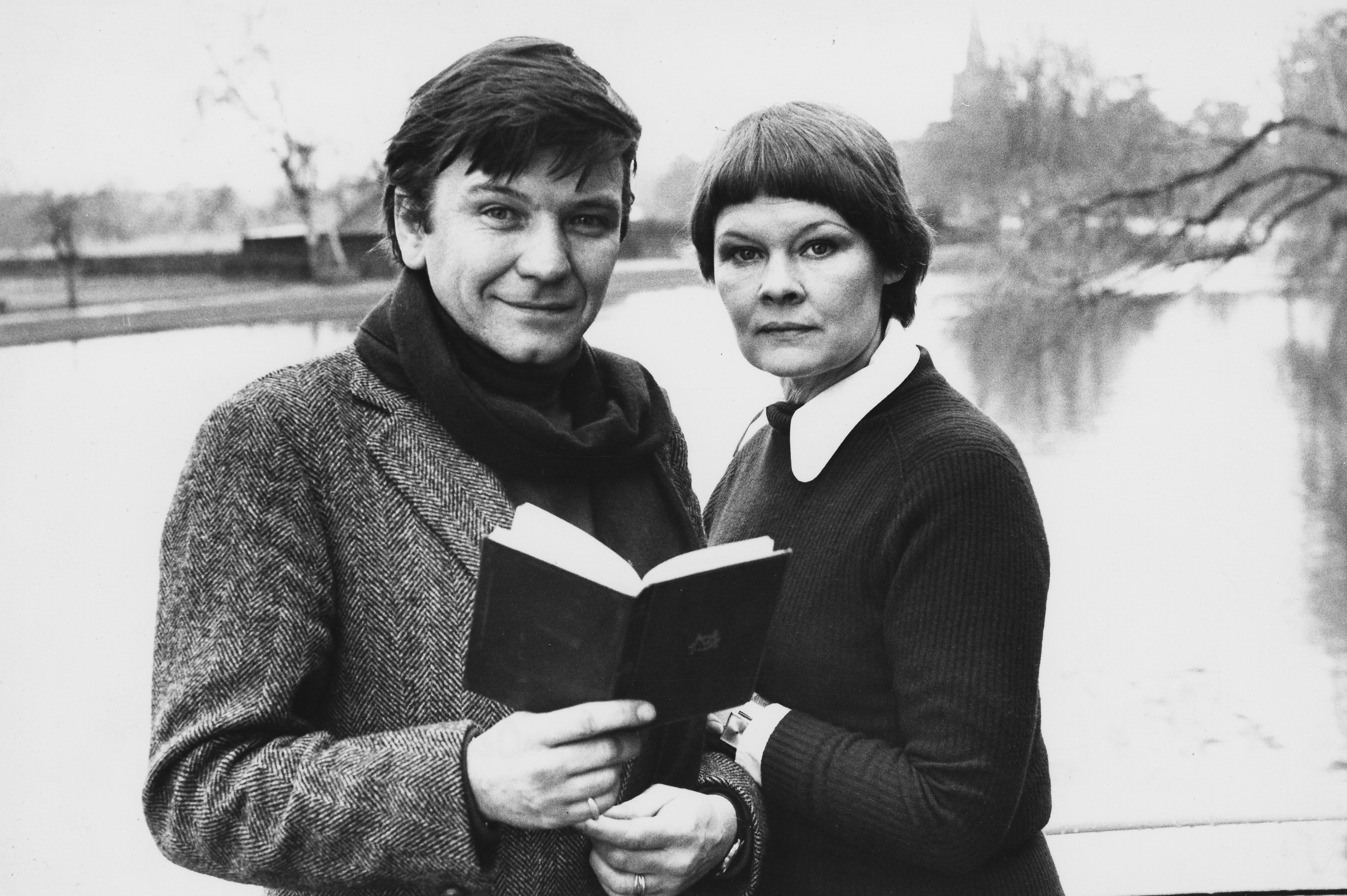 Michael Williams and Judi Dench pose standing next to a river on January 27, 1977 ┃Source: Getty Images