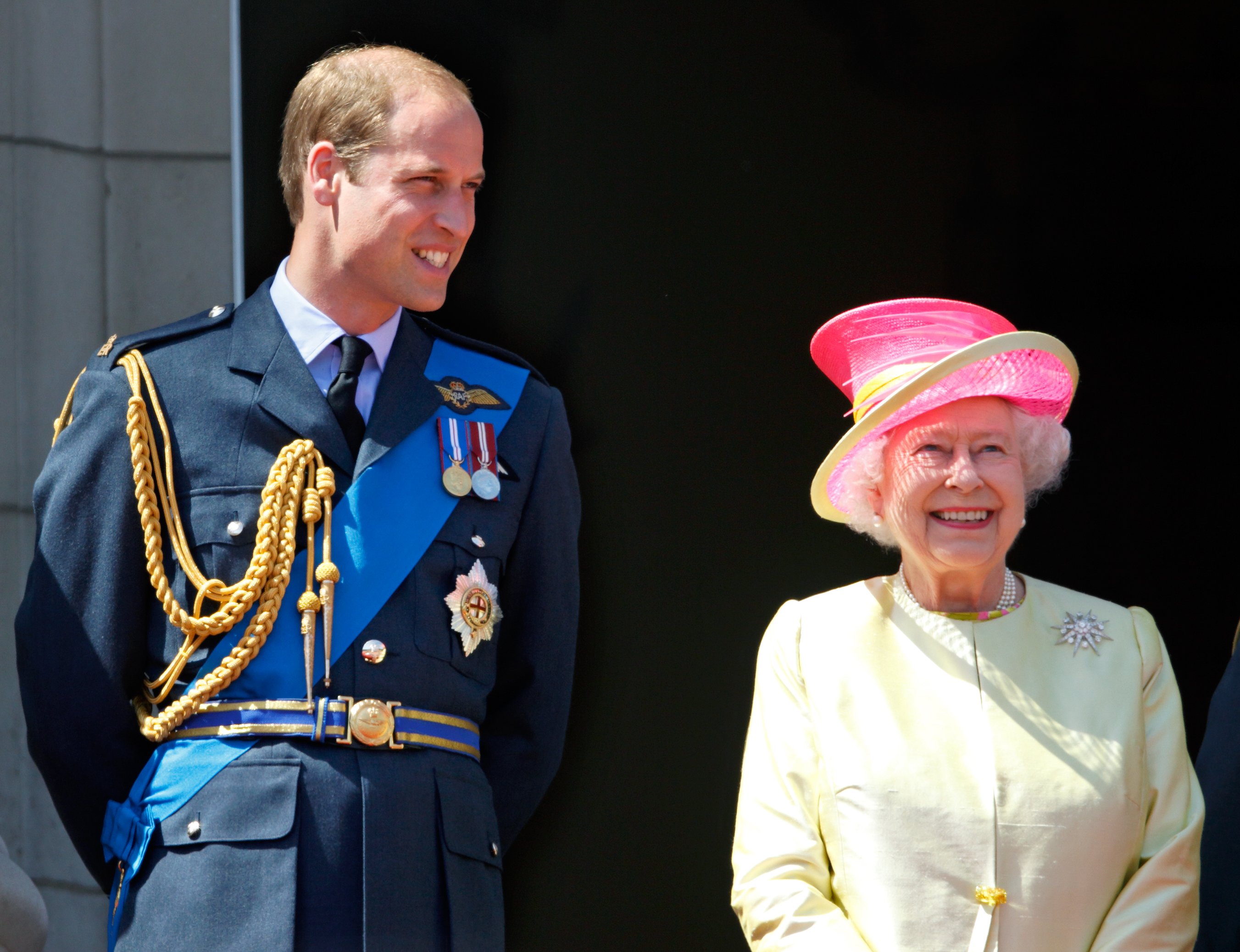 Prince William and Queen Elizabeth II watch a flypast of Spitfire & Hurricane aircraft from the balcony of Buckingham Palace on July 10, 2015 in London, England | Source: Getty Images