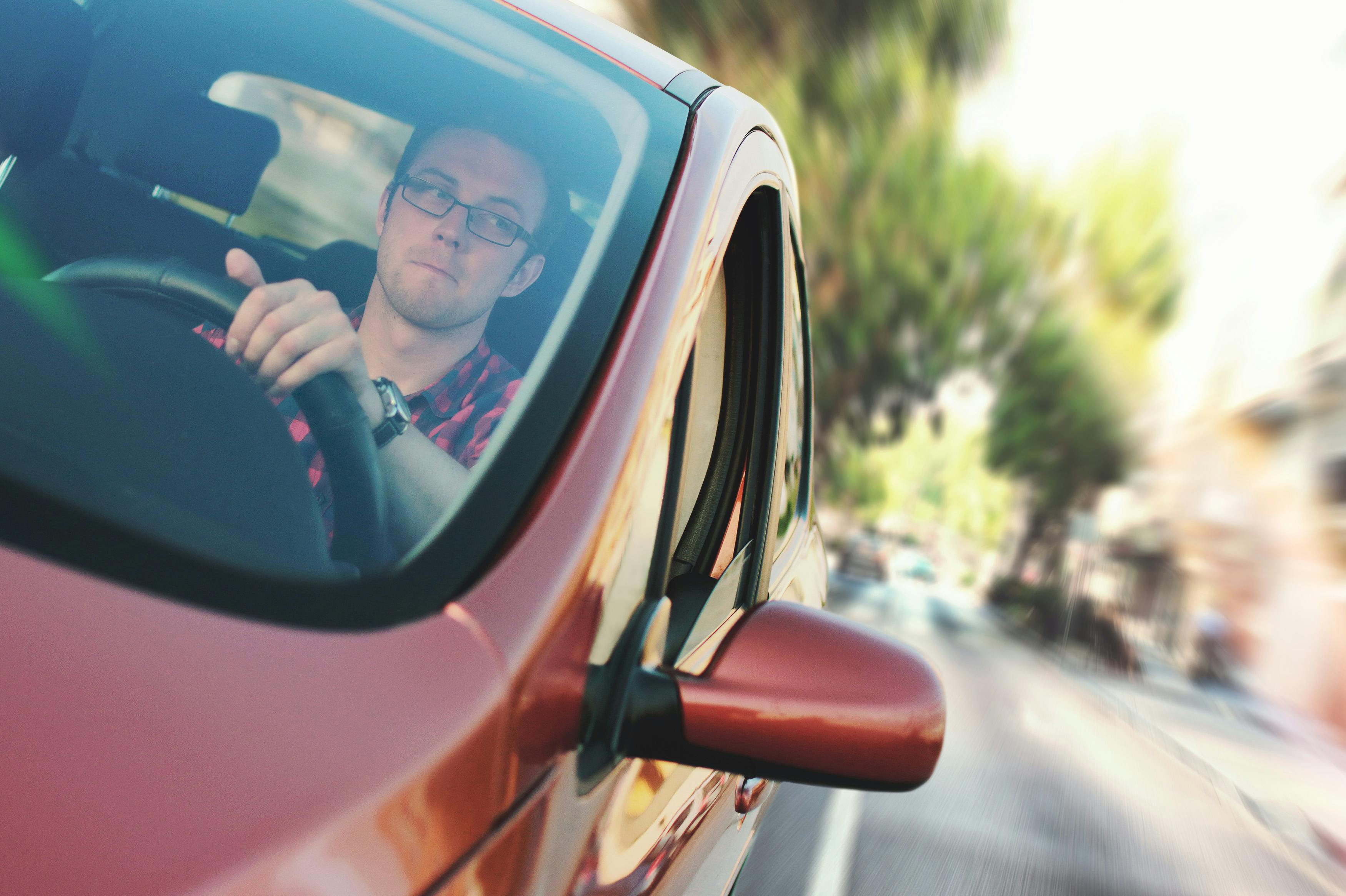 A man driving a red car | Source: Pexels