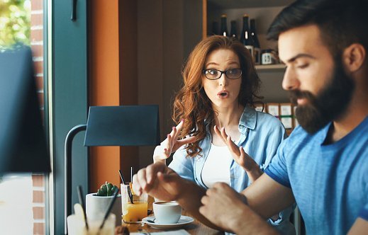 Photo of closeup side view of mid 20's couple having an argument at a coffee place | Photo: Getty Images