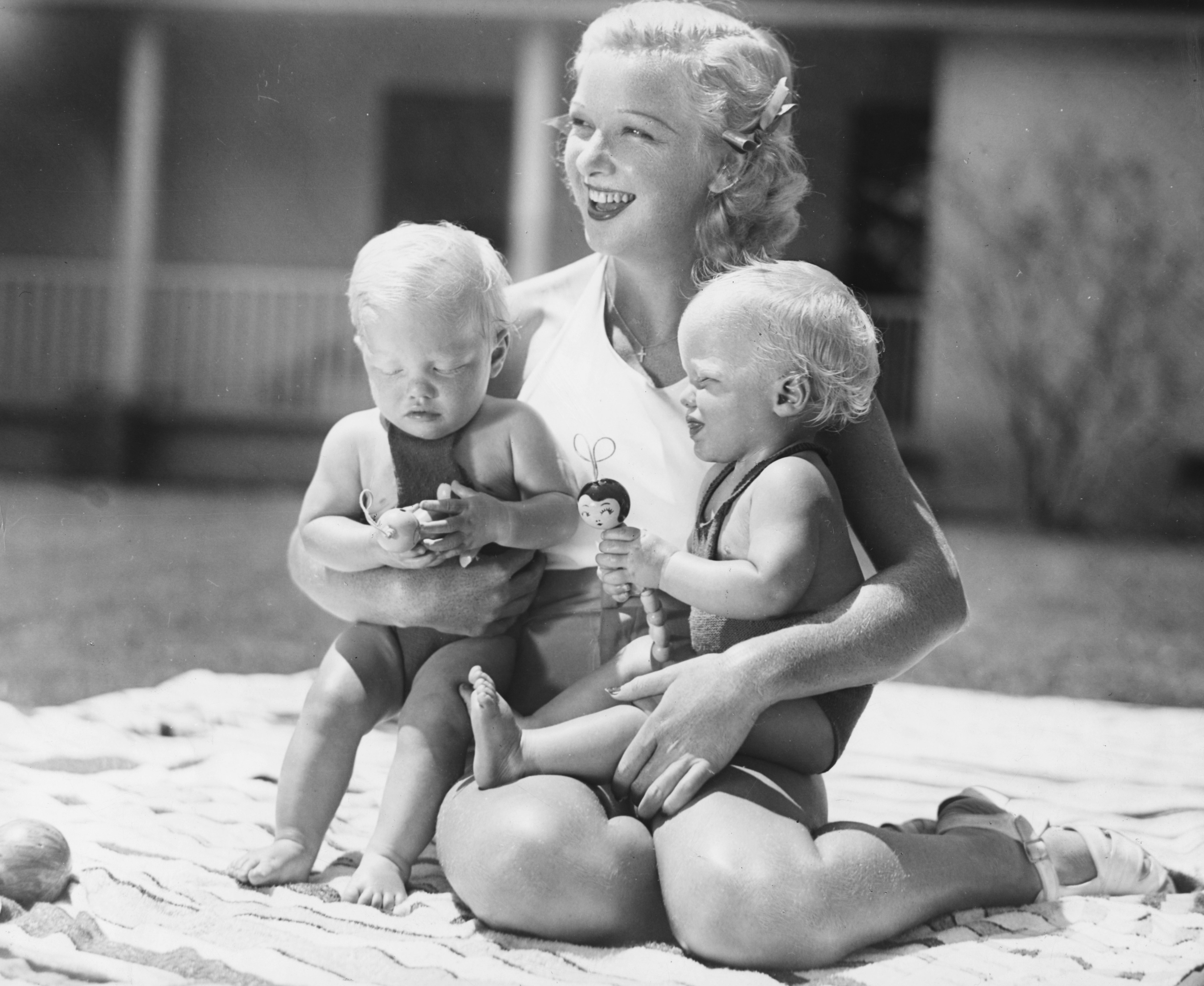 Actress Dixie Lee, wife of singer Bing Crosby, relaxing outdoors with their twin sons Dennis and Phillip, circa 1935. | Source: Getty Images