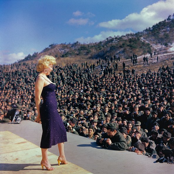 Marilyn Monroe Posing on Stage in Front of Troops as she performs in in Korea | Photo: Getty Images