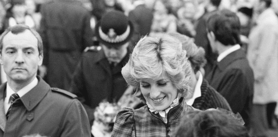 The Prince and Princess of Wales visit Mid Glamorgan in Wales, behind Princess Diana is bodyguard Barry Mannakee wearing a diagonal striped tie and overcoat/mac on January 29, 1985 | Source: Getty Images