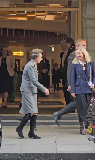 Princess Anne pauses outside The Cumberland Hotel in London, England, to warmly shake hands with a woman waiting nearby, maintaining her characteristically composed demeanour while wearing a tailored grey skirt suit and her well-known suede riding boots in a clip from a post dated 5 March 2026. | Source: Instagram/kingsguardchannel