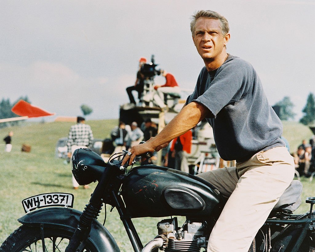 Steve McQueen sitting astride a motorcycle in a publicity image issued for the film, 'The Great Escape', in 1963. | Photo: Getty Images