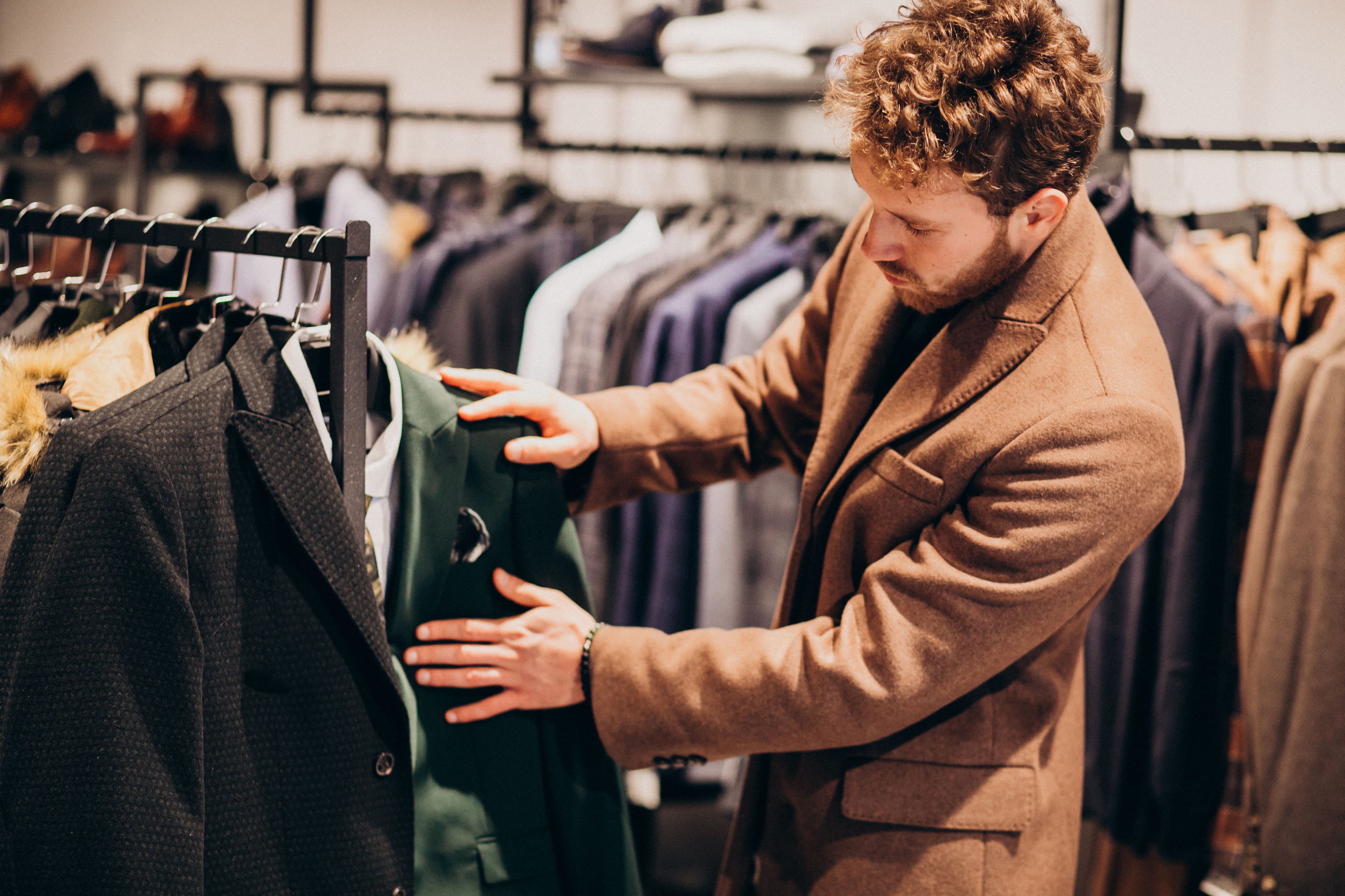 A man looking at outfits curiously | Source: Freepik