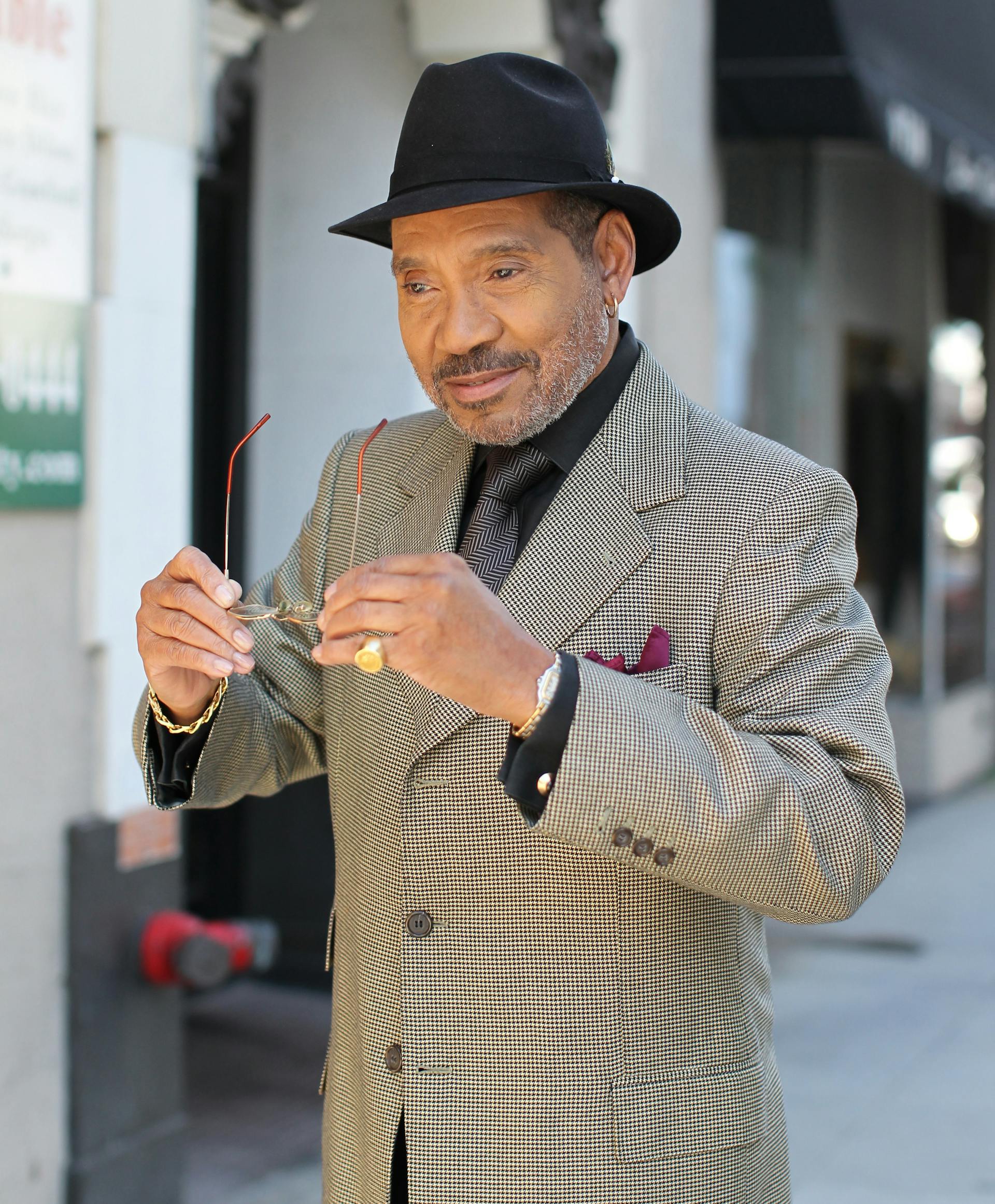 A man wearing a black fedora holding his glasses | Source: Pexels