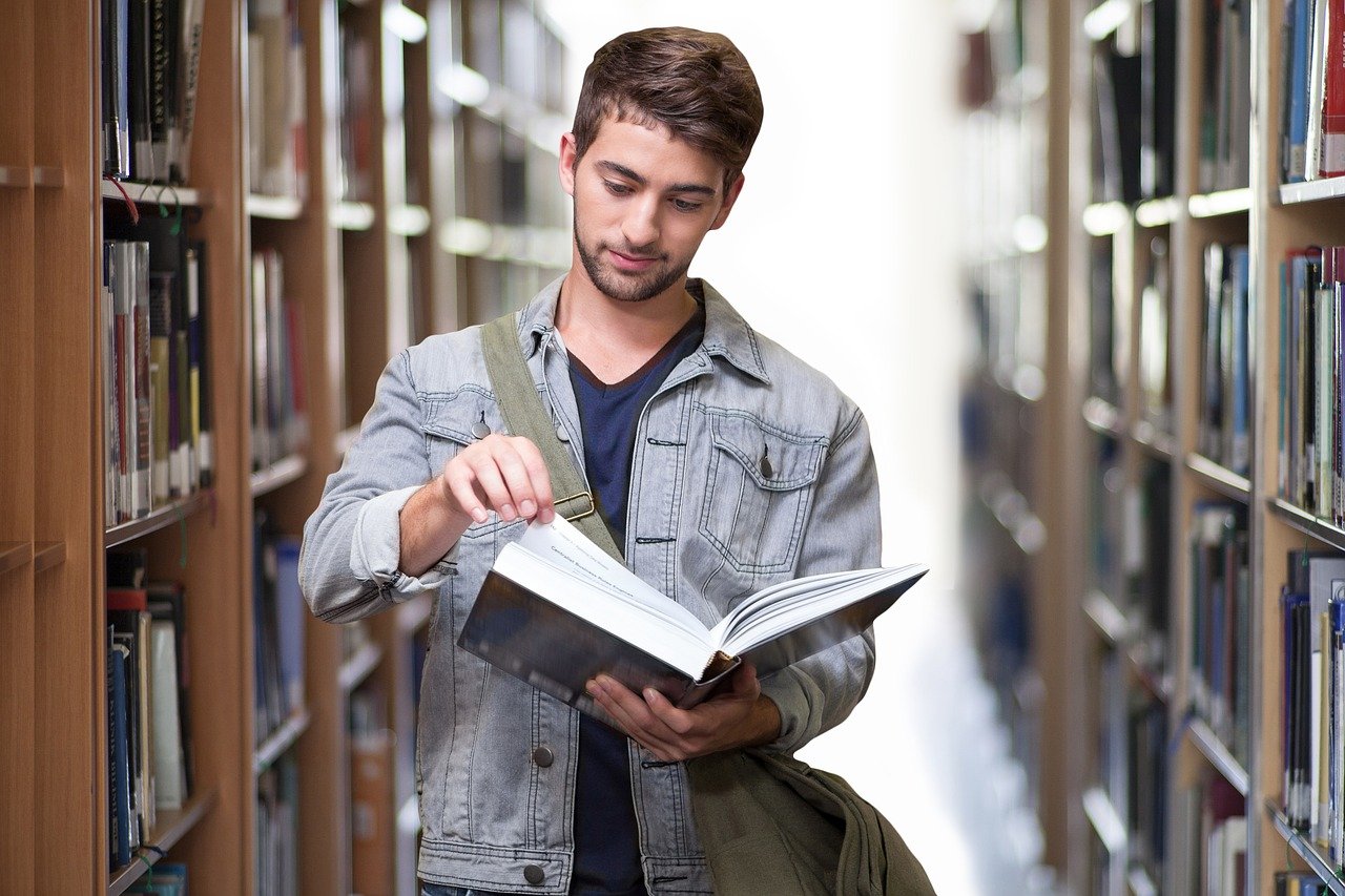 A photo of a male college student in a library. | Photo: Pixabay