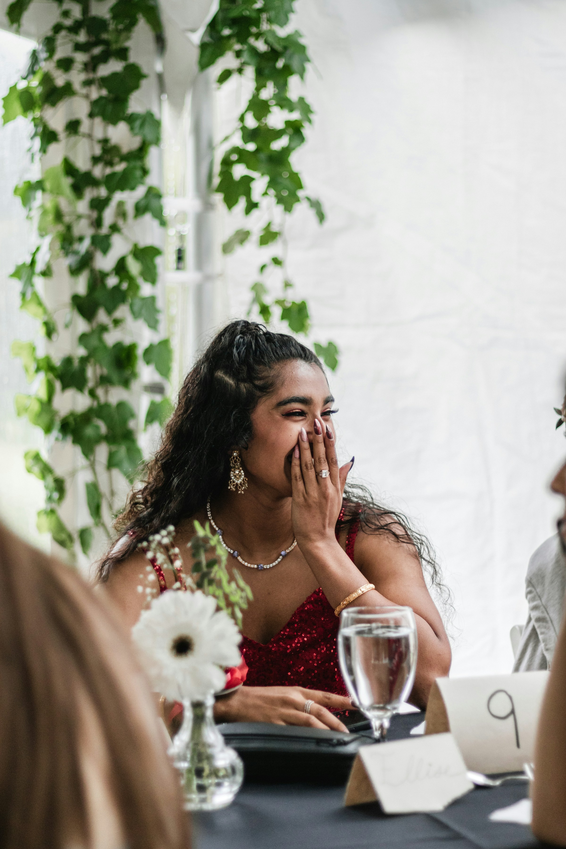 A woman covers her face while laughing at an event | Source: Unsplash
