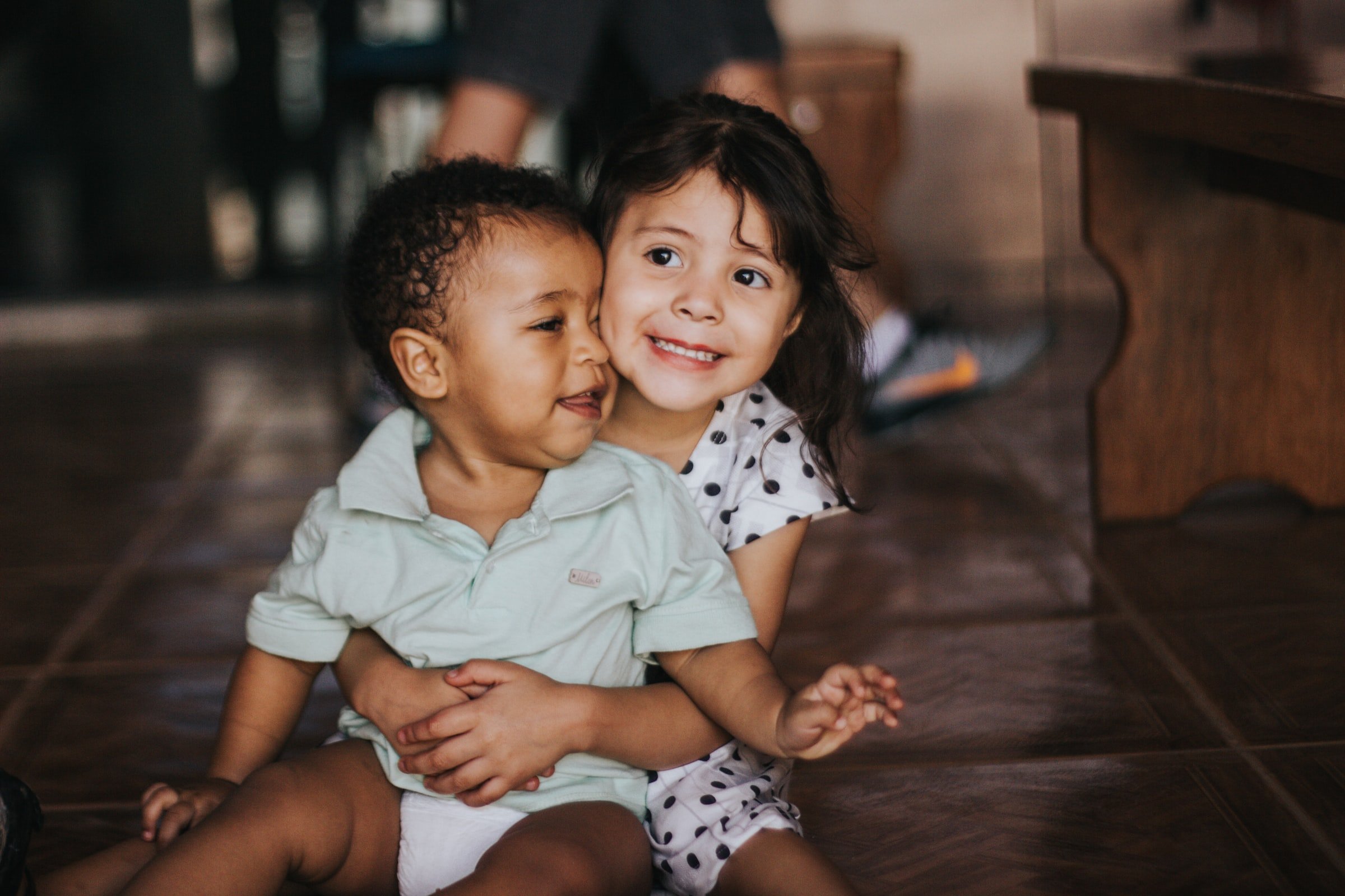 A little girl holding a baby. | Source: Unsplash