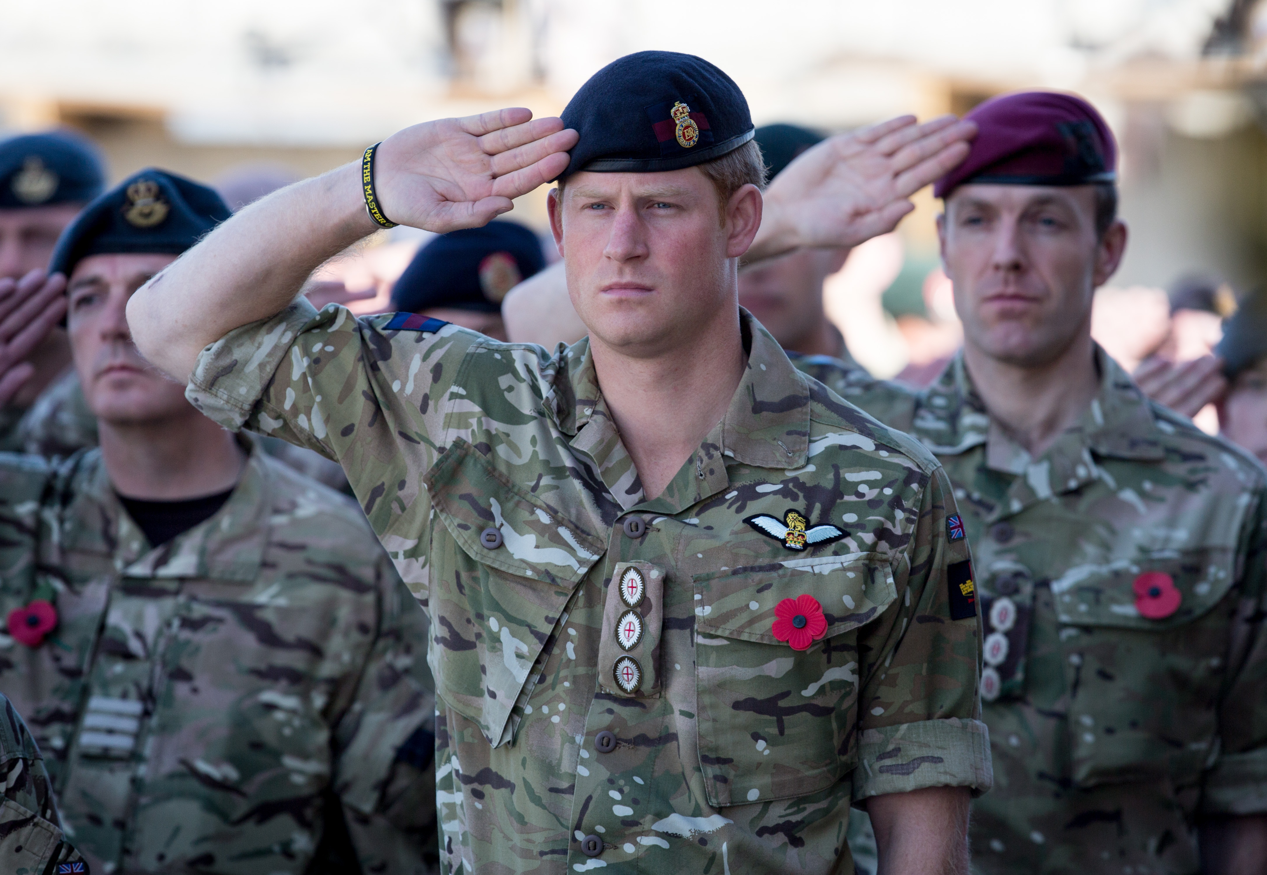 Prince Harry salutes as the Last Post is played during a Remembrance Sunday service at Kandahar Airfield on November 9, 2014 in Kandahar, Afghanistan. | Source: Getty Images