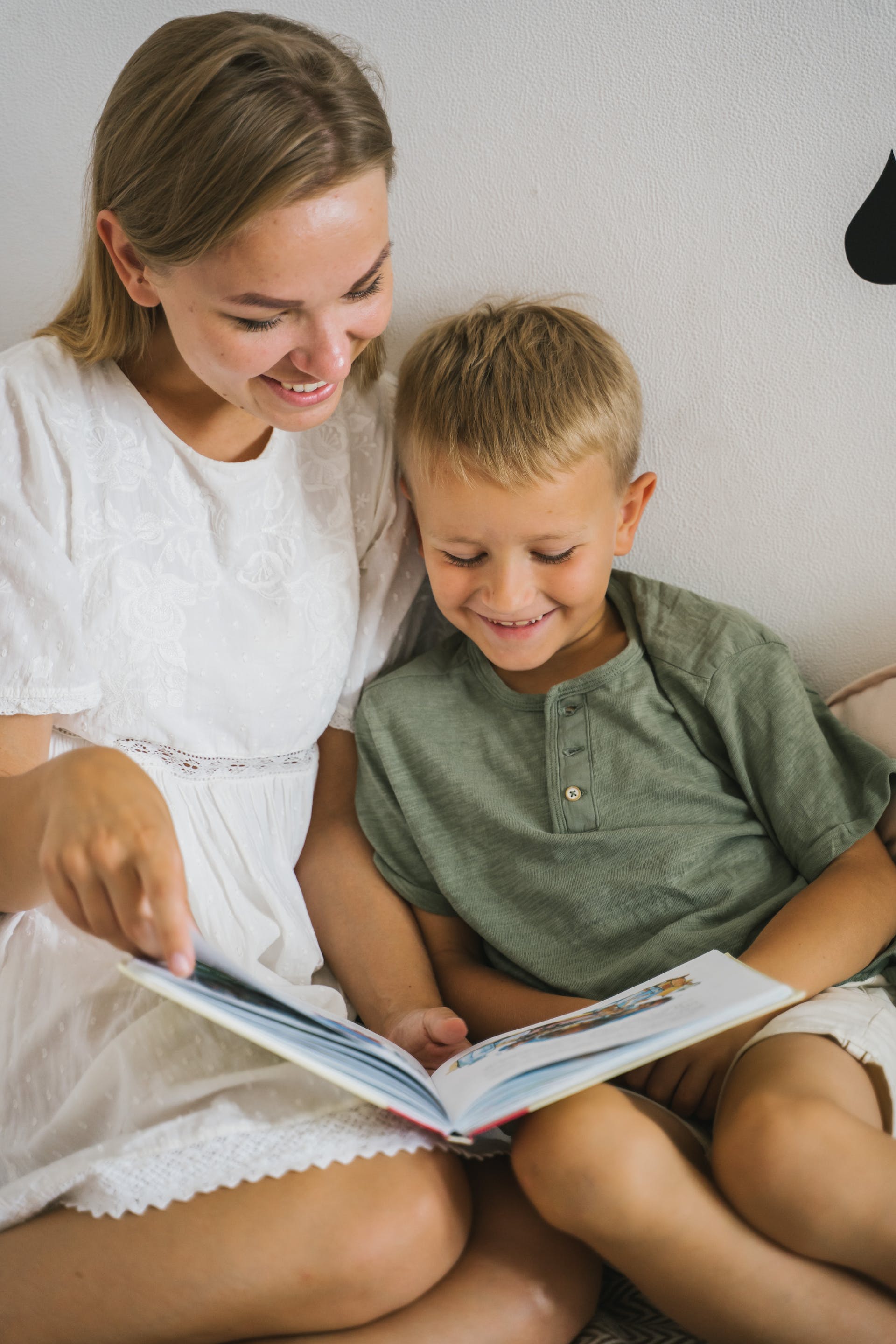 Mother reading a book with her son | Source: Pexels