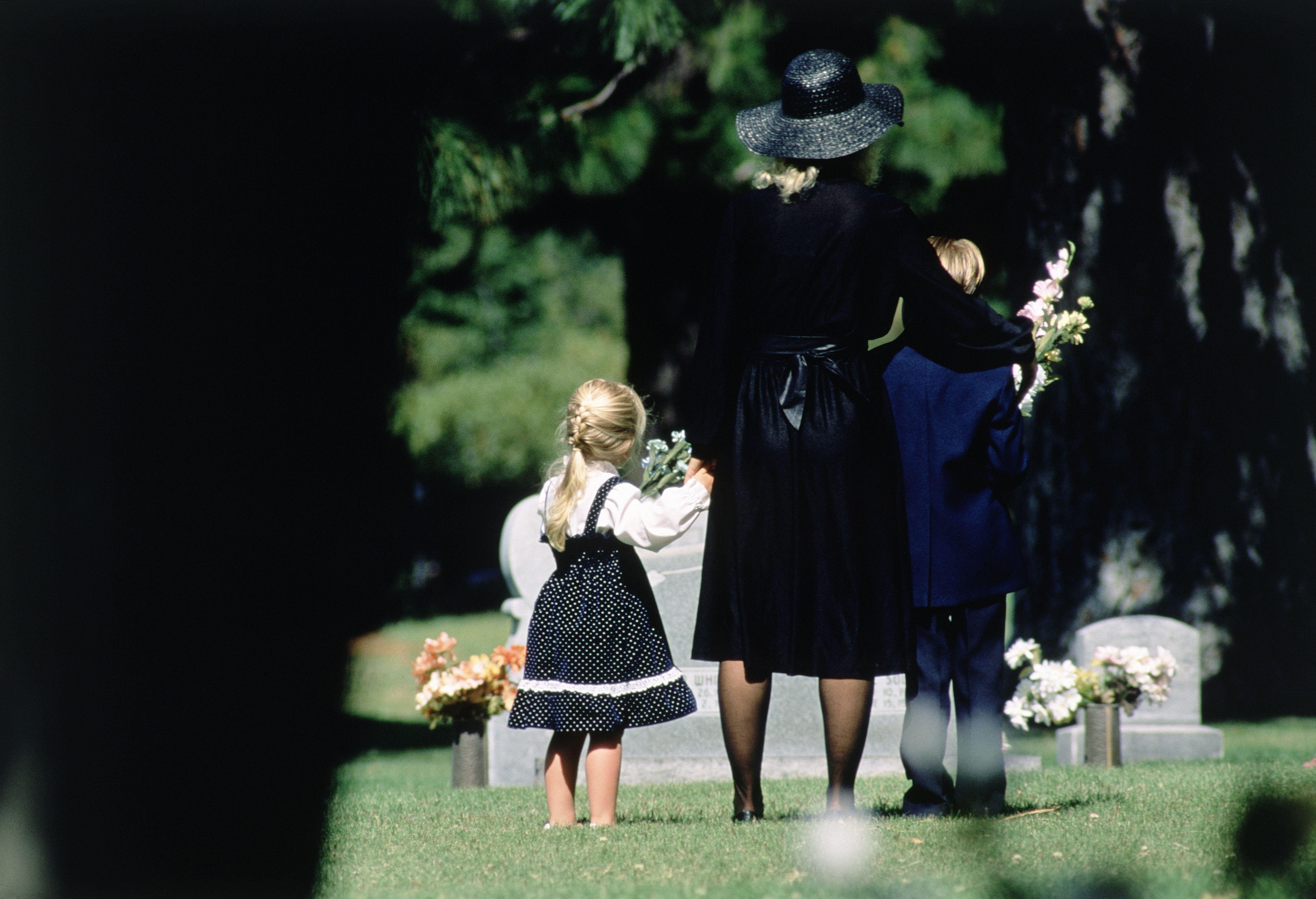 A mother and her children attend a funeral | Source: Getty Images
