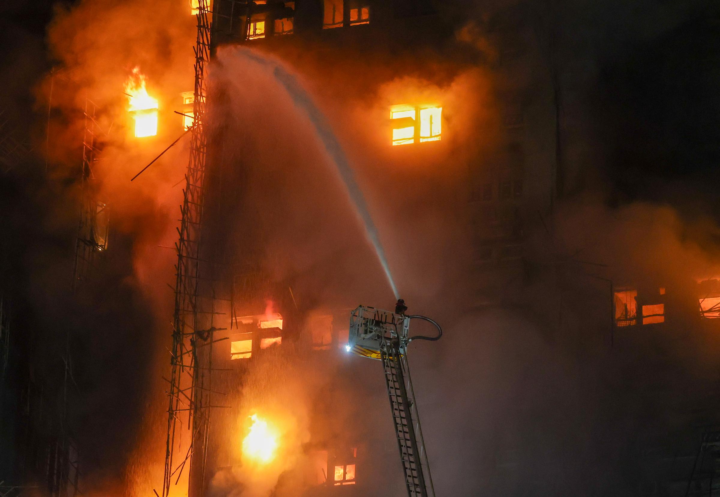 Firefighters use aerial ladders to battle flames at Wang Fuk Court in Tai Po, Hong Kong, on November 26, 2025 | Source: Getty Images