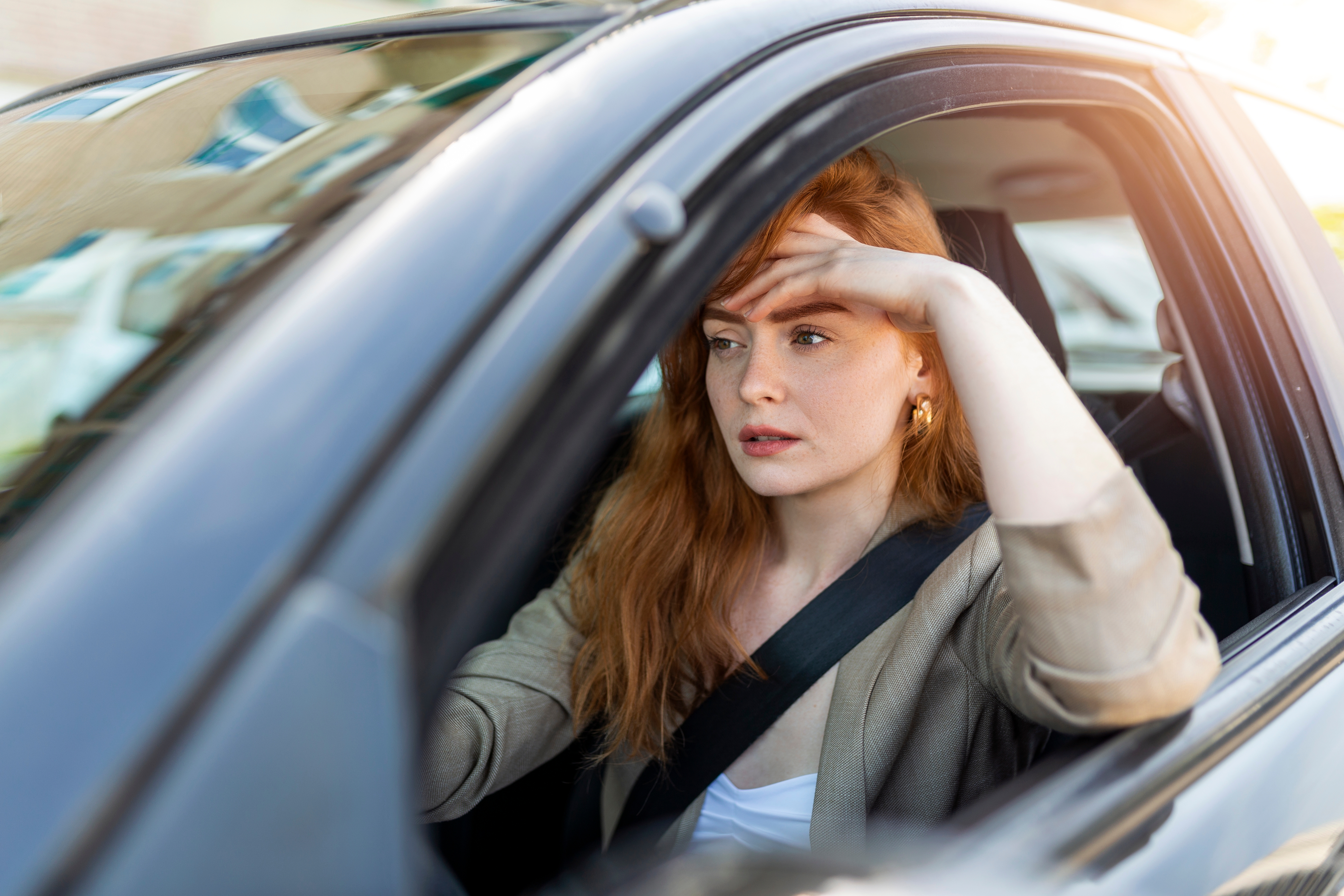 A woman looking like she is deep in thought while driving | Source: Shutterstock