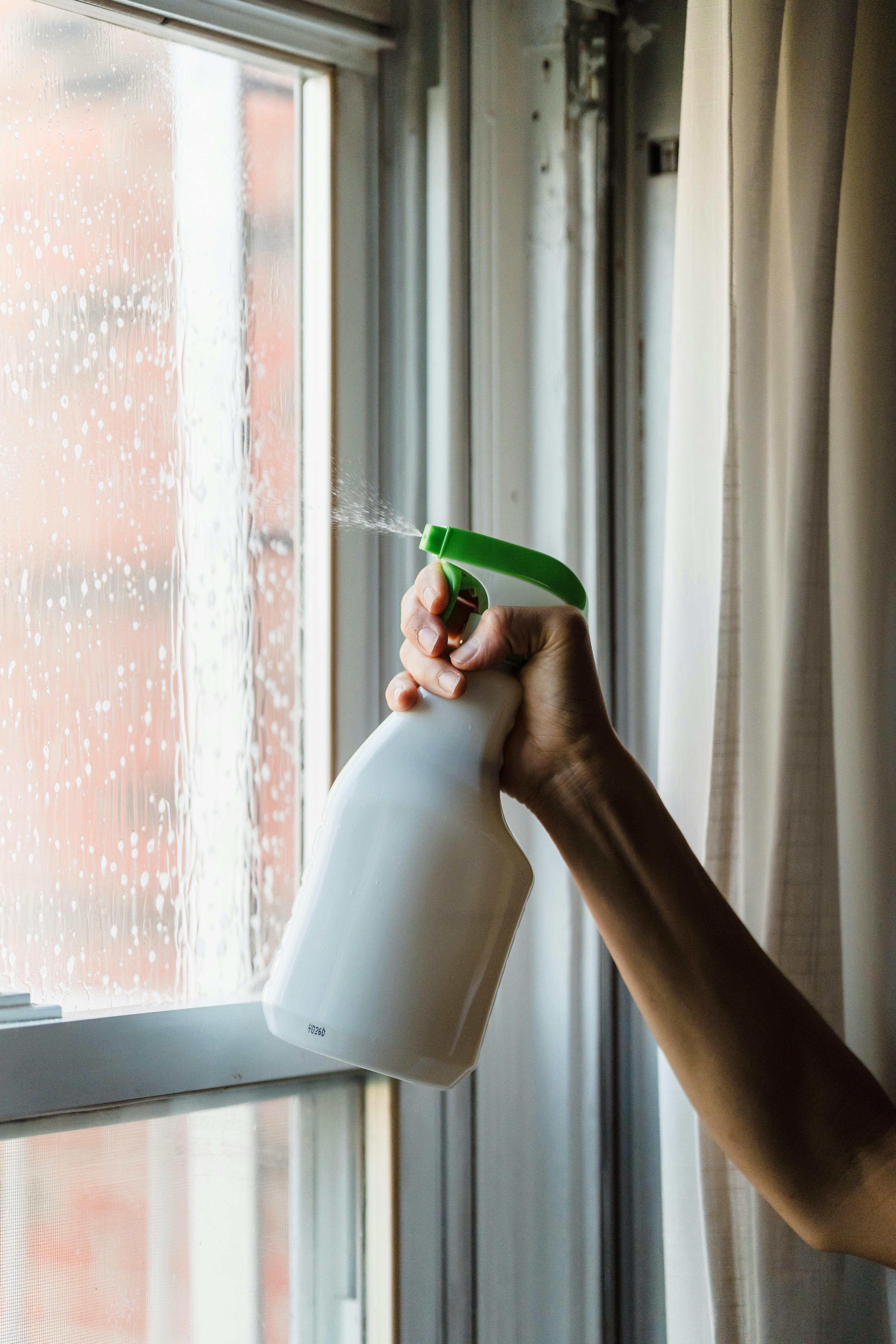 Spraying solution on a glass window | Source: Pexels