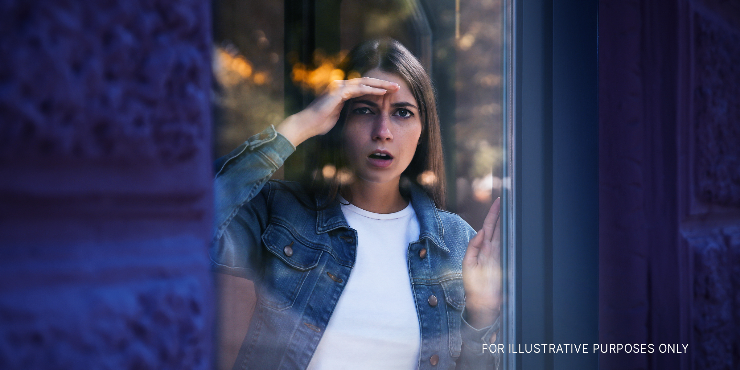 Woman looking at something through window | Source: Shutterstock