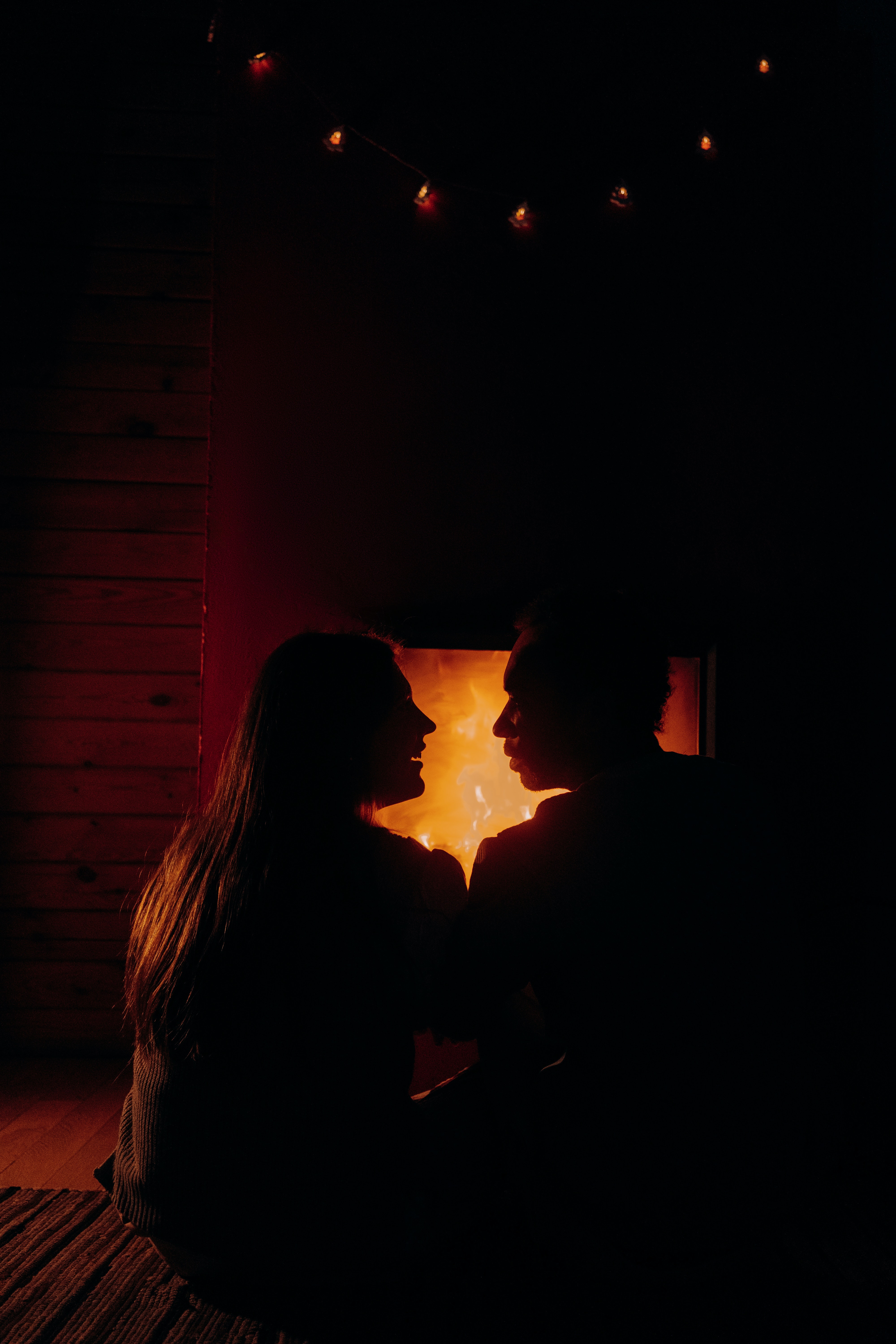 Two people sitting in front of a fire. | Source: Pexels