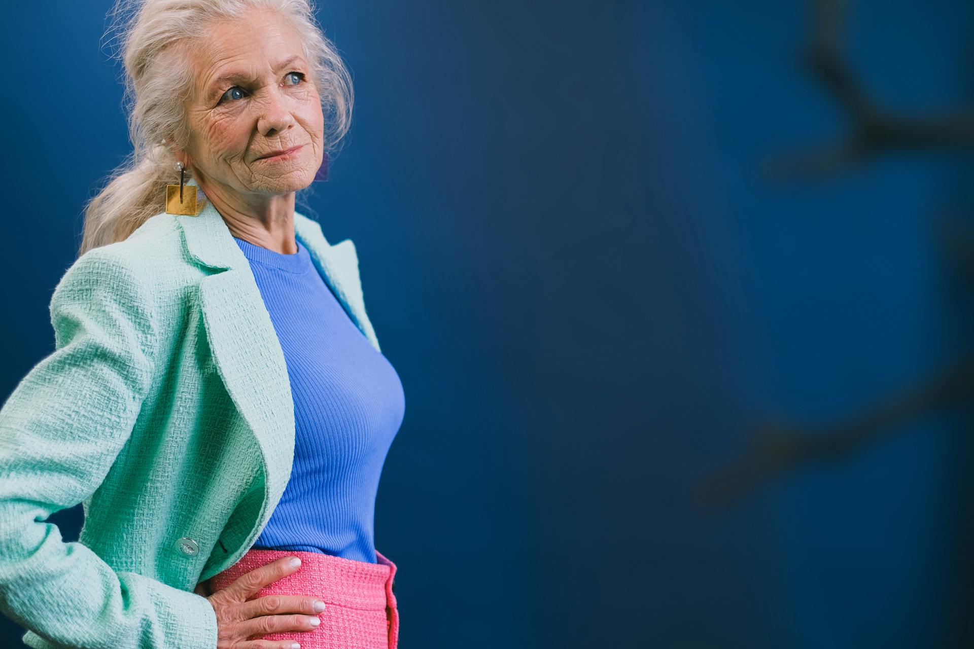 Side view of a smiling older lady with her hands on her hip | Source: Pexels