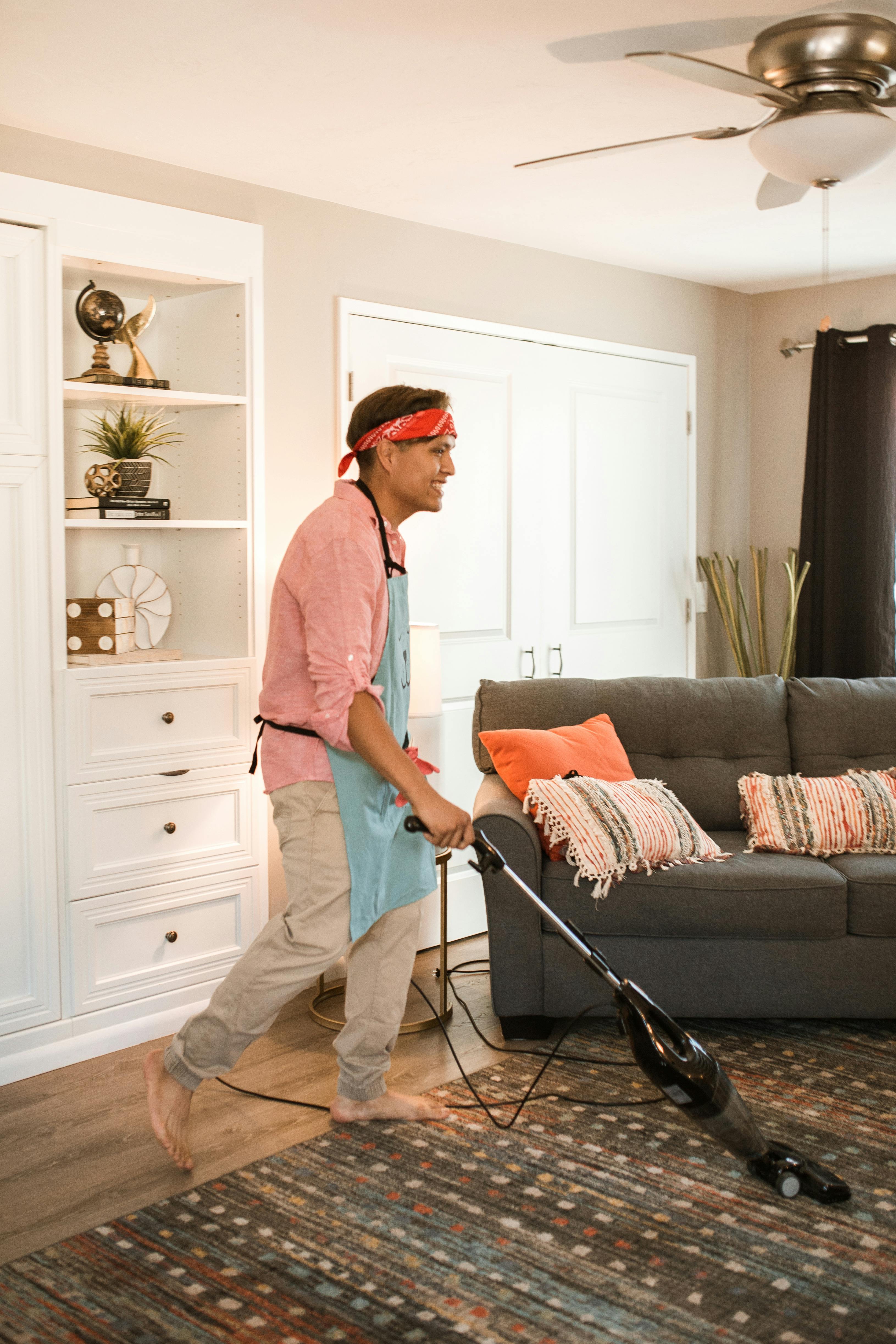 A man vacuuming the living room floor | Source: Pexels