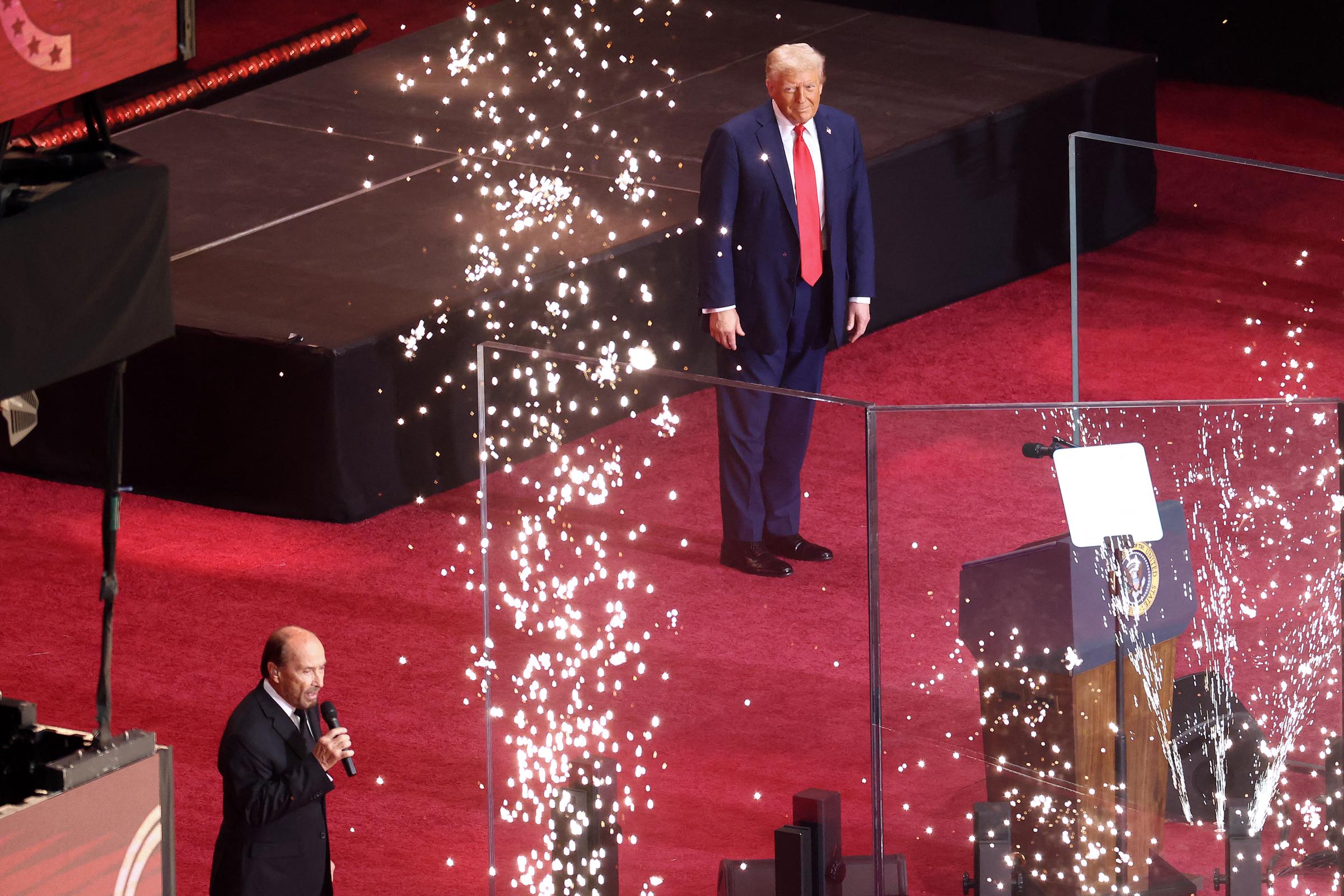Donald Trump walks on stage as Lee Greenwood performs during the public memorial service for Charlie Kirk at State Farm Stadium on September 21, 2025, in Glendale, Arizona | Source: Getty Images