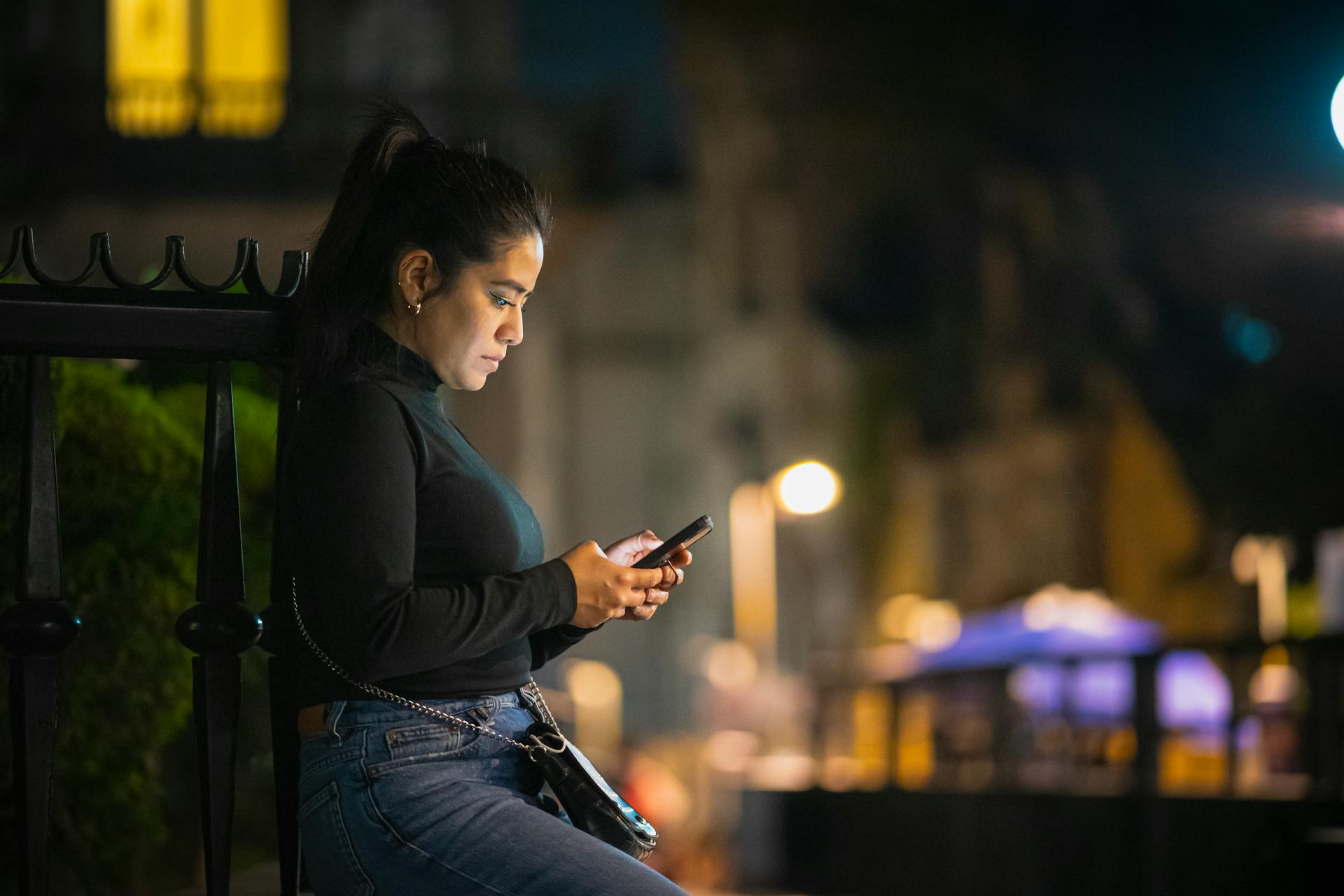 A woman holding a phone at night | Source: Pexels