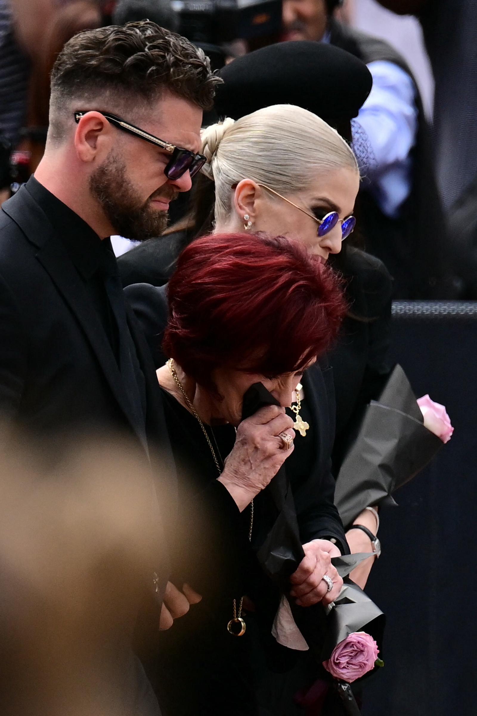Ozzy Osbournes widow, Sharon and their children, Jack and Kelly arrive to lay flowers at the Black Sabbath Bridge bench on Broad Street during a funeral procession for the late lead singer.