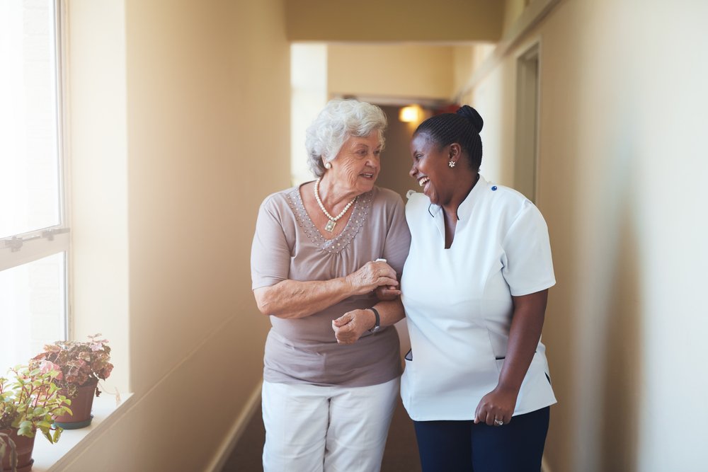 Professional caregiver taking care of elderly woman | Photo: Shutterstock