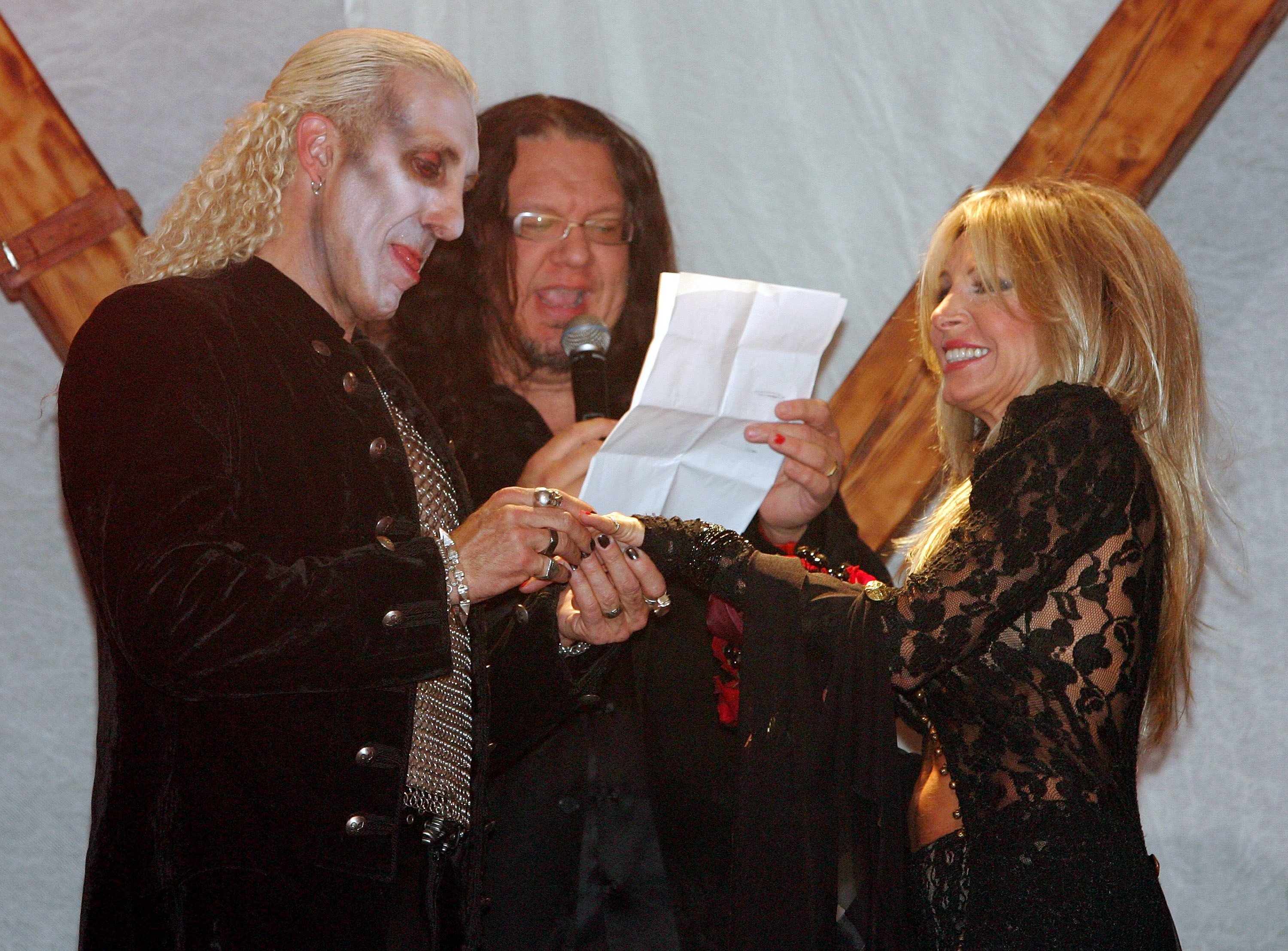 Penn Jillette (C) officiating the wedding vow renewal ceremony for Twisted Sister singer Dee Snider (L) and Suzette Snider at the Hard Rock Hotel & Casino on October 21, 2006, in Las Vegas, Nevada. | Source: Getty Images