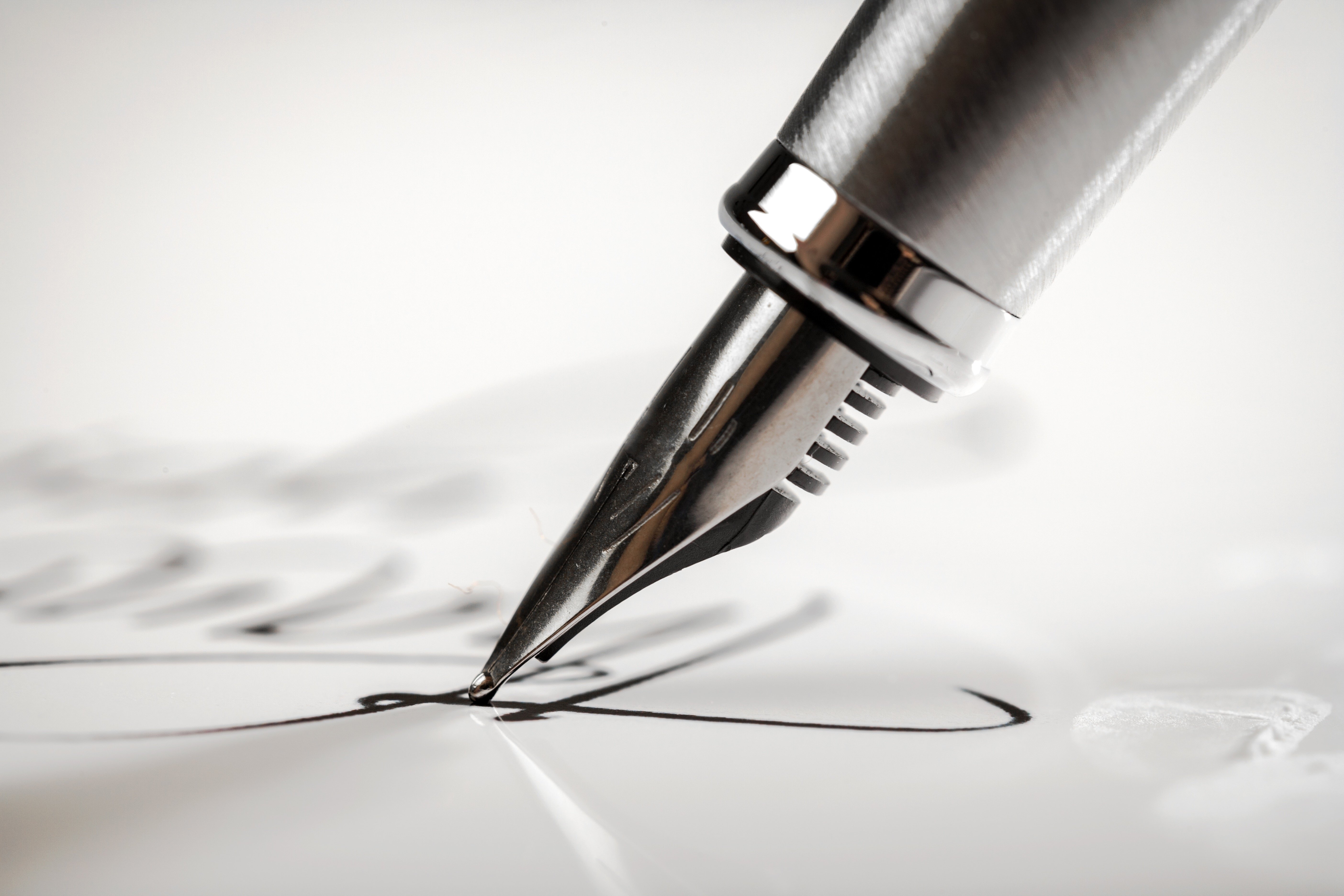 A pen being used to write on paper. | Source: Shutterstock