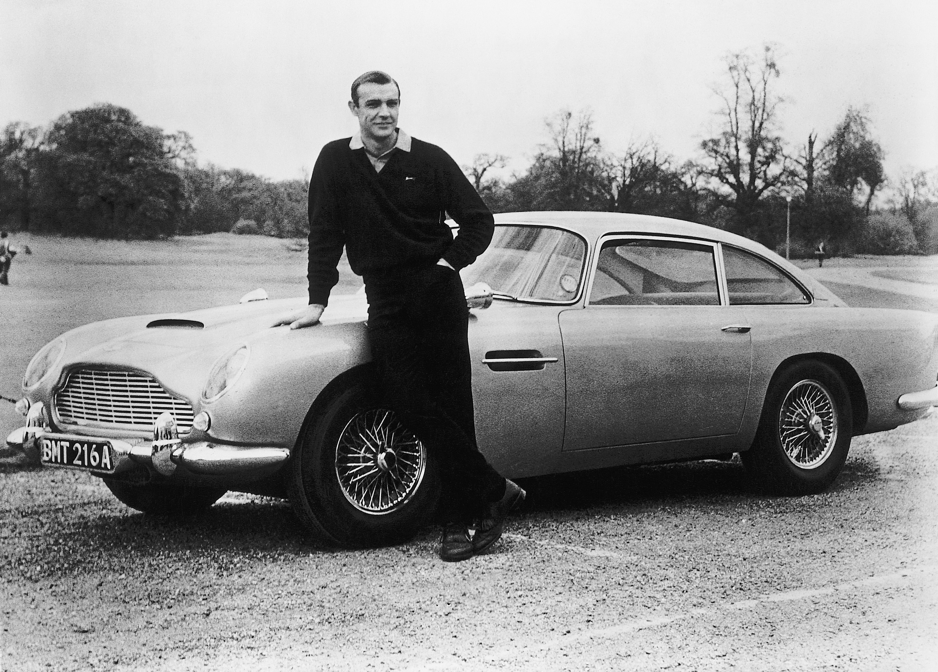 Sean Connery pictured on the set of "Goldfinger" with one of the fictional spy's cars, a 1964 Aston Martin DB5. / Source: Getty Images