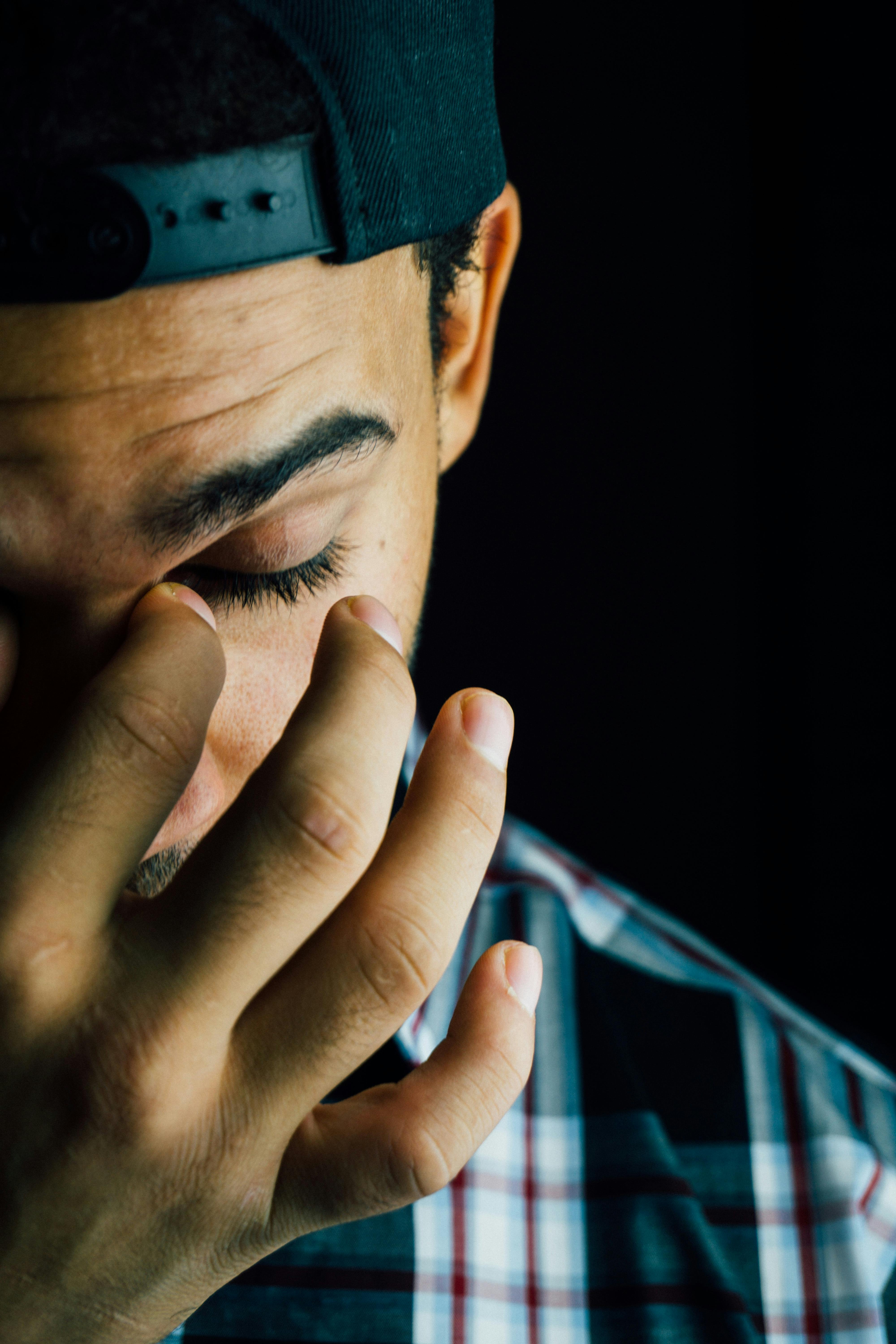 A frustrated man pinching the bridge of his nose | Source: Pexels