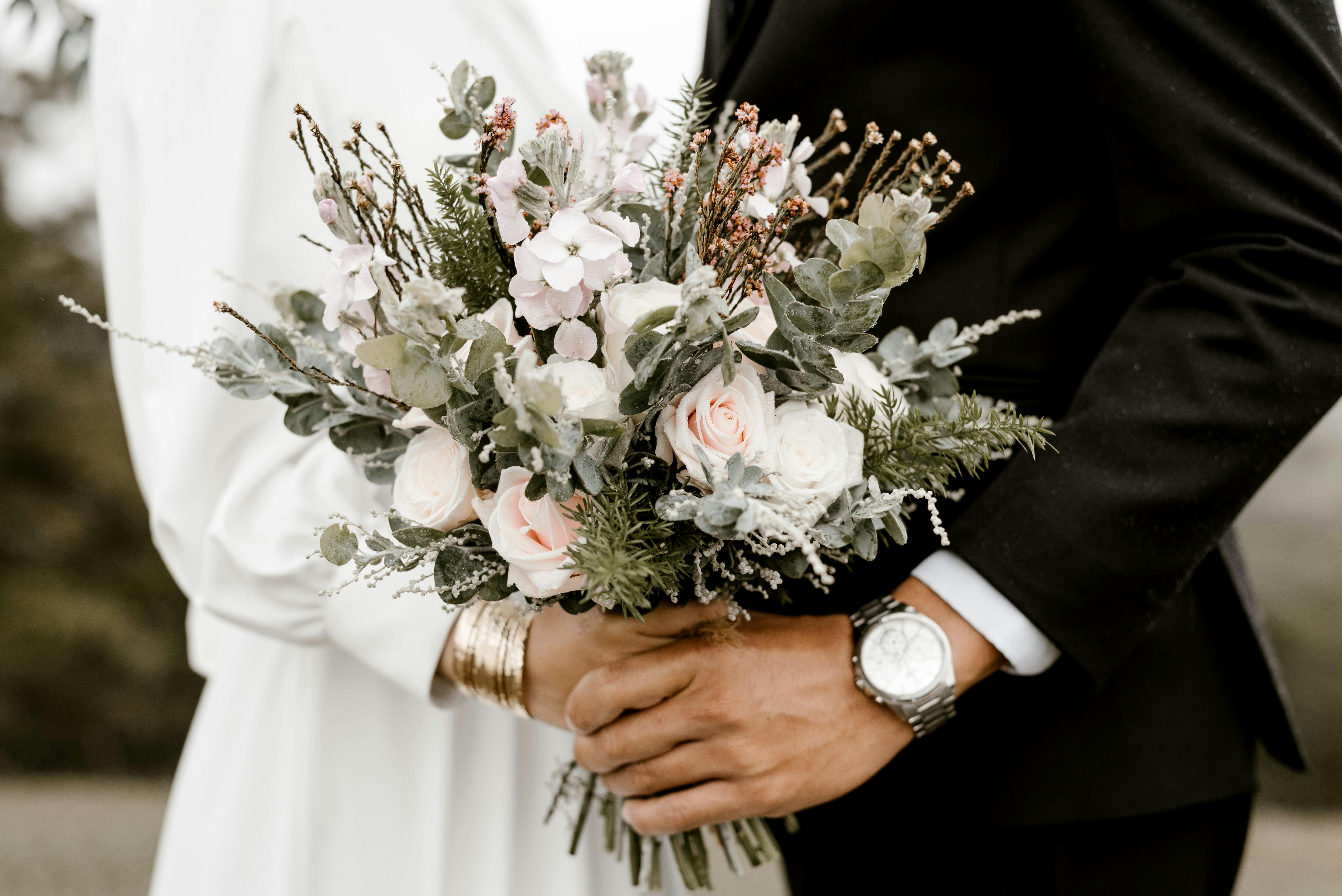 Groom and bride dance holding a wedding bouquet | Source: Pexels