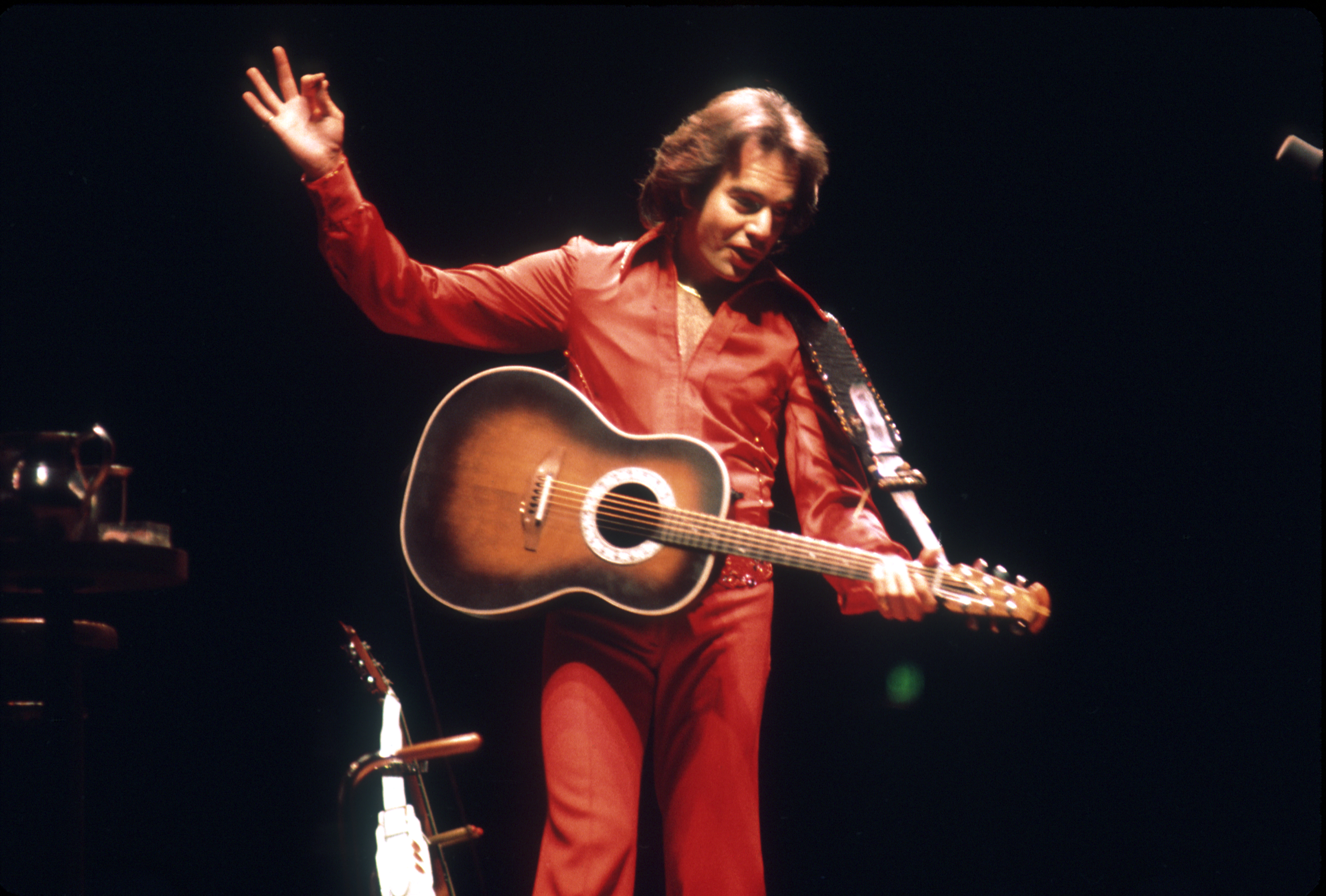 Singer Neil Diamond performs onstage wearing a red jumpsuit on January 1, 1980 in Los Angeles, California | Source: Getty Images