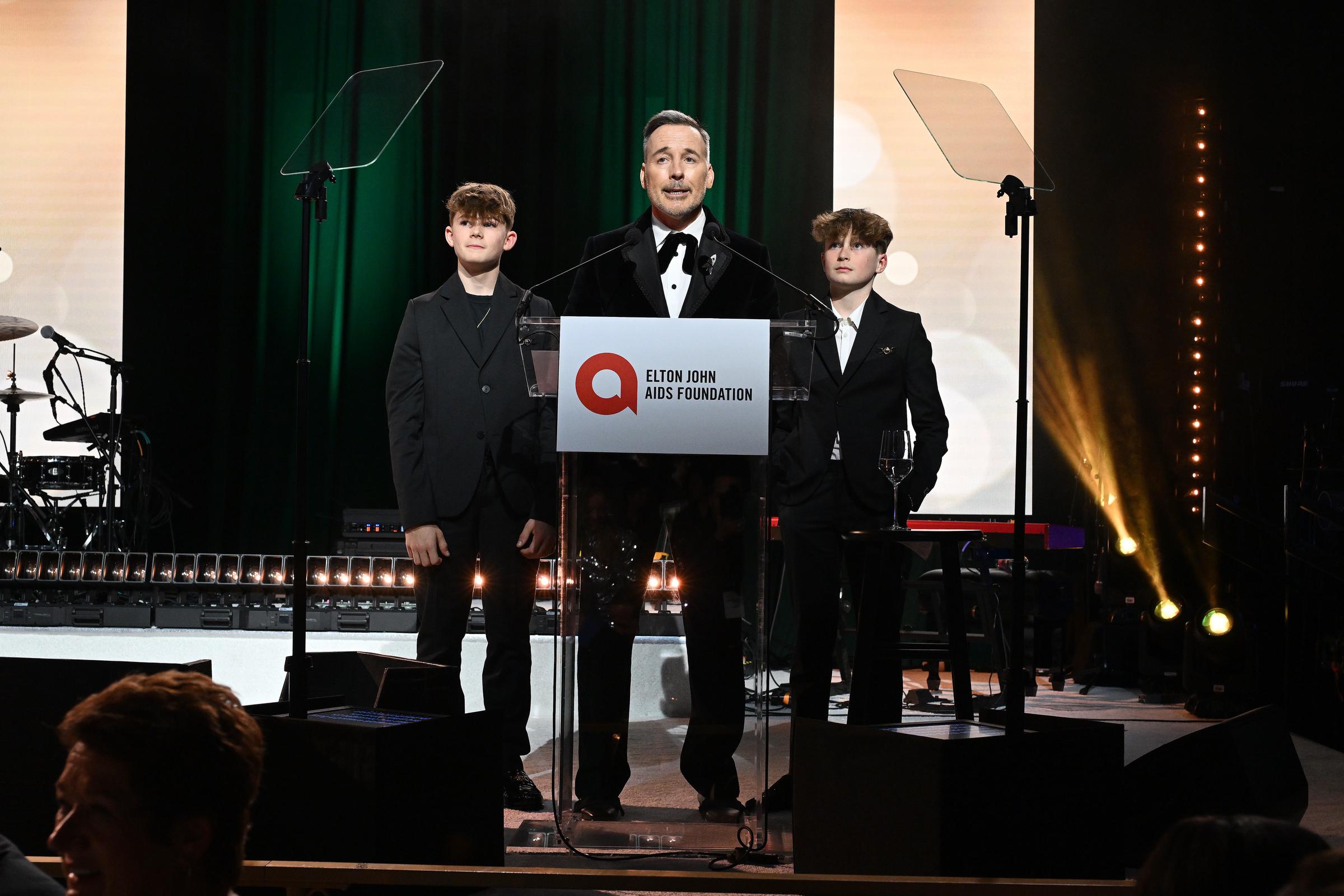 Zachary Jackson and Elijah Joseph Daniel Furnish-John onstage with their dad David Furnish. | Source: Getty Images