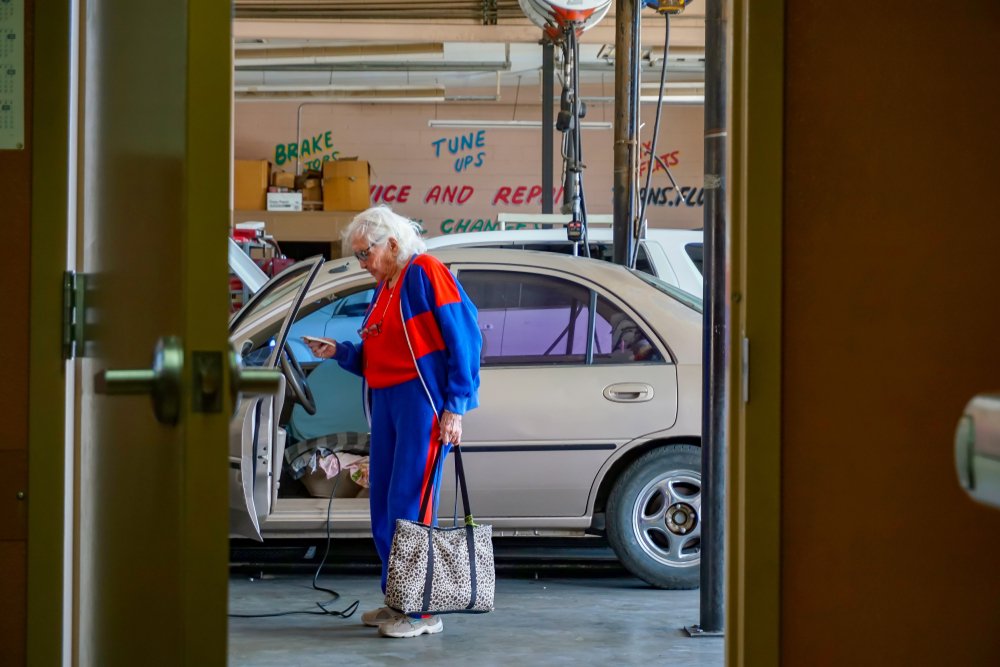Elderly woman standing near a car in a parking garage | Photo: Shutterstock